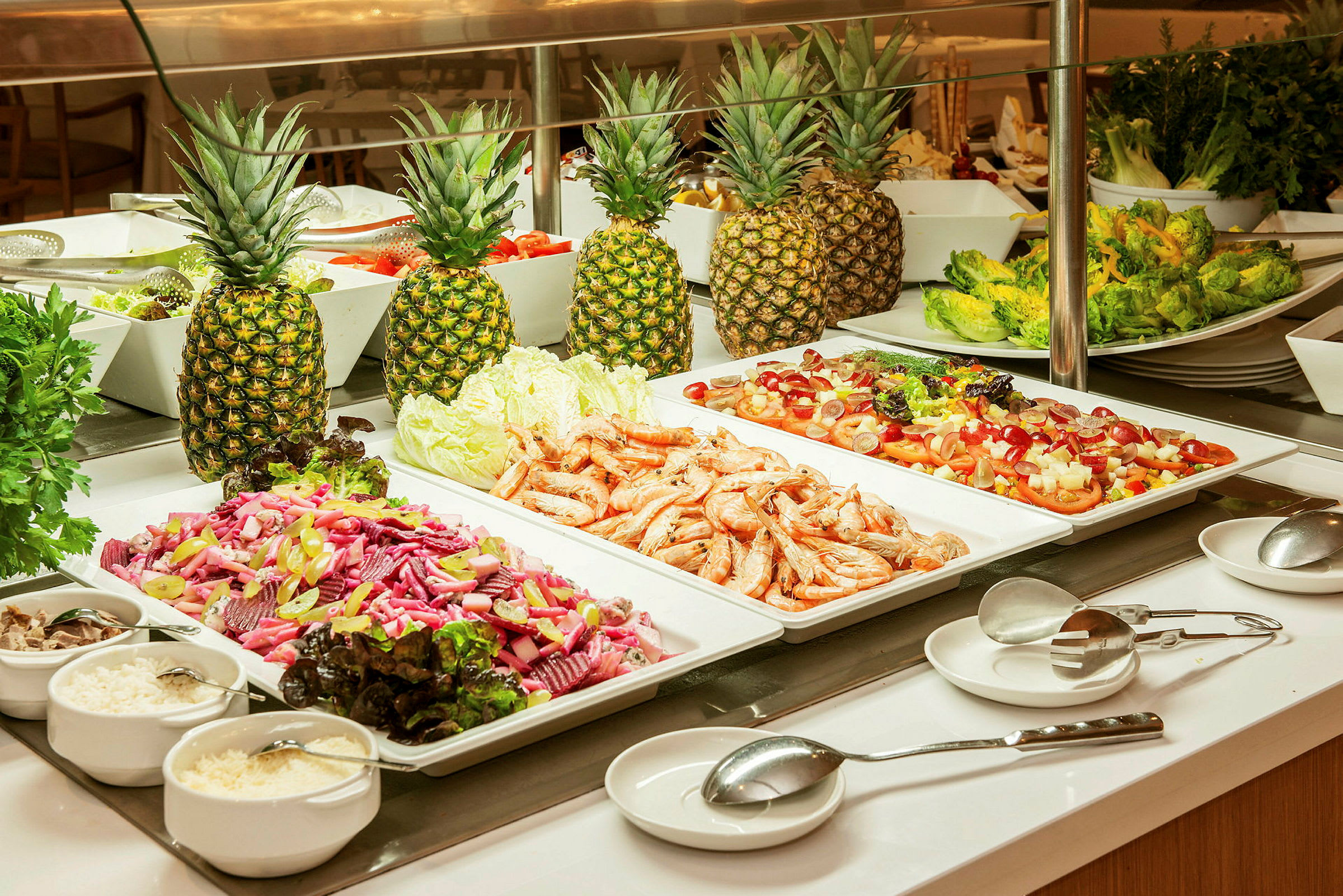 Buffébord med sallad, räkor och ananas. (AI-genererad text)