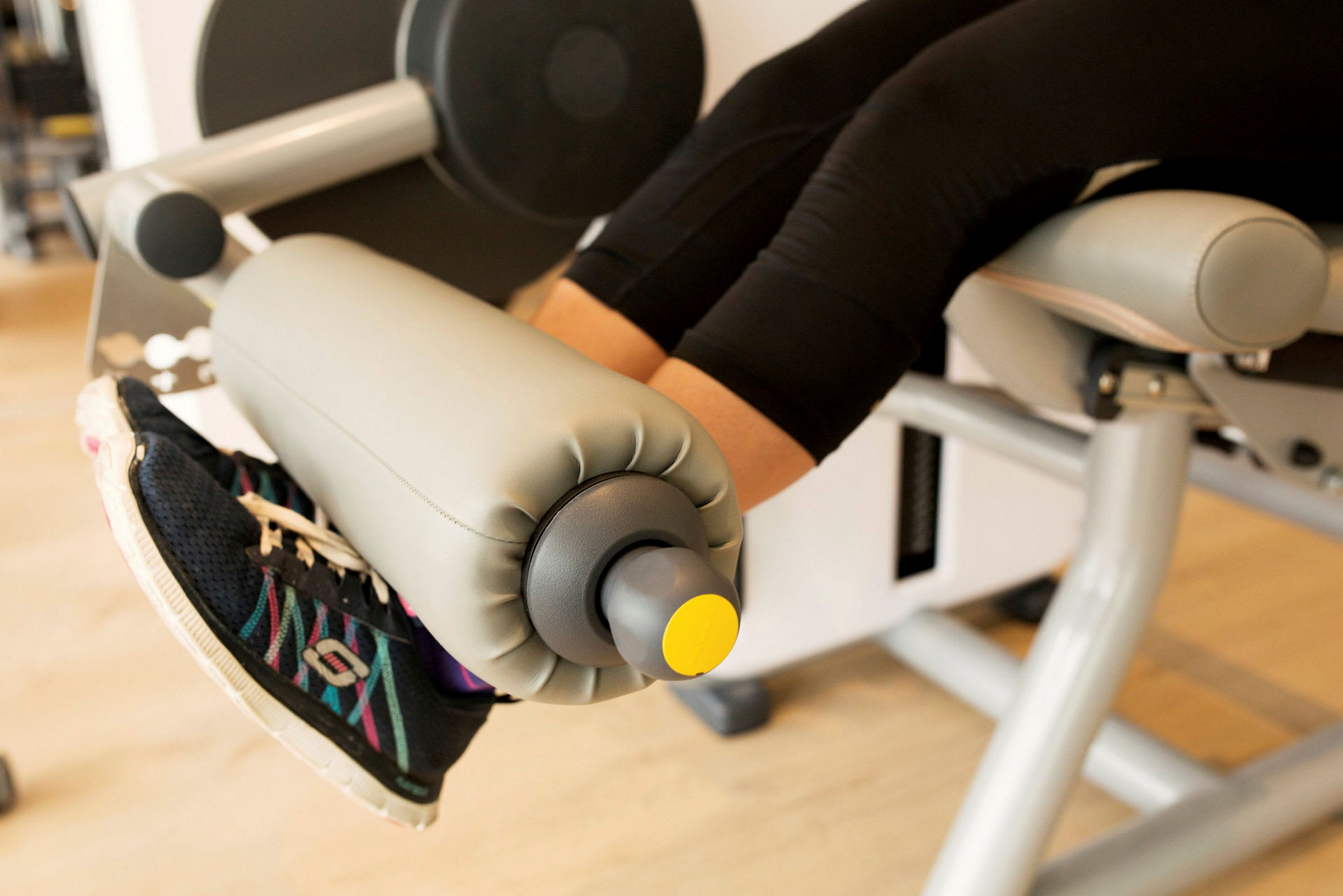Bilden visar ett par ben med träningsskor som använder en bensparkmaskin på ett gym. (AI-genererad text)