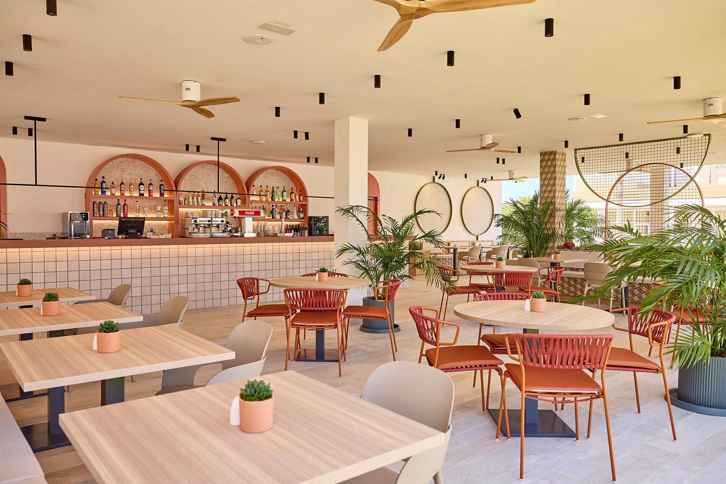 En modern bar och restaurang med bord, växter och en elegant inredning. (AI-genererad text)