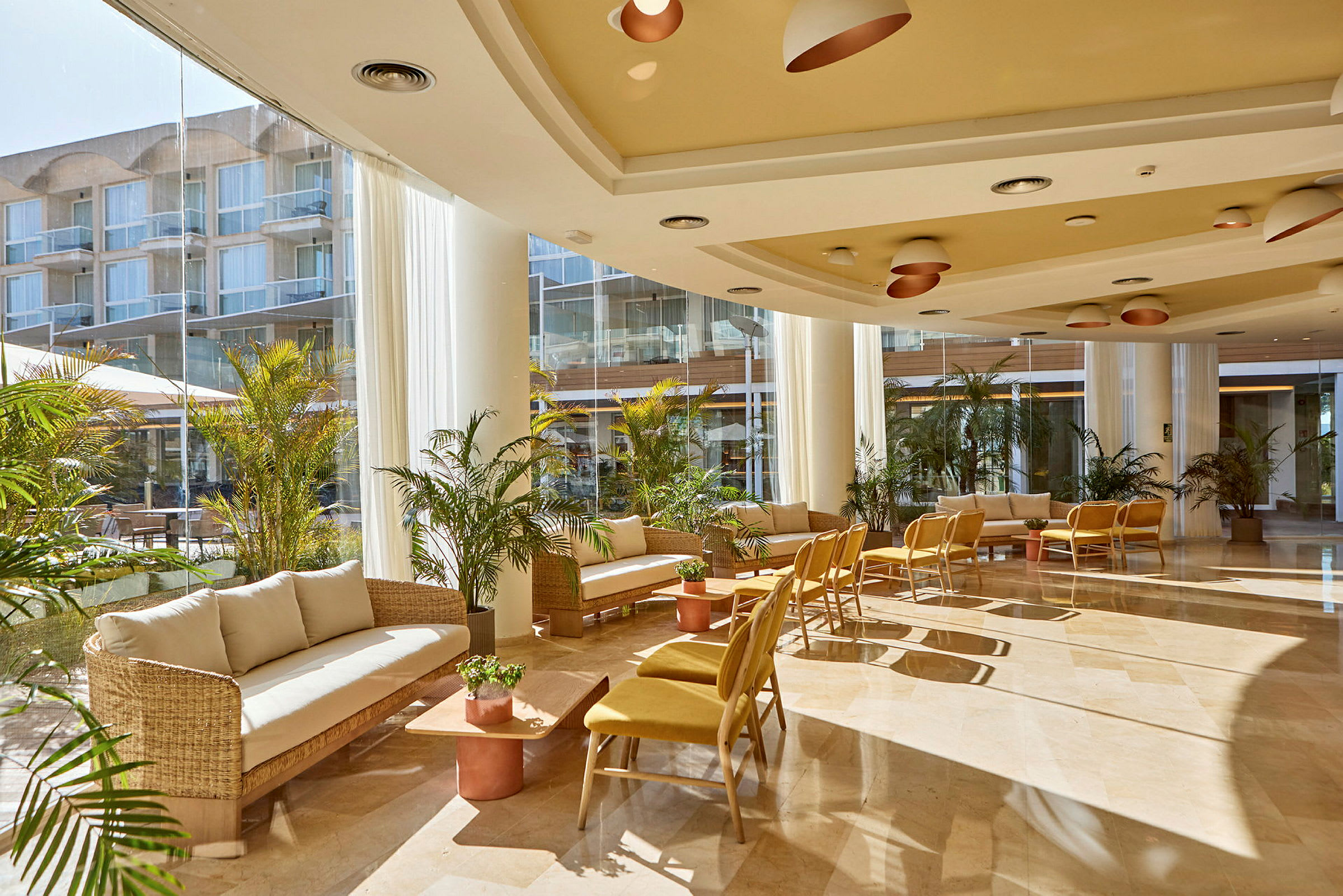 Interiör av en ljus och modern hotellobby med sittmöbler och växter. (AI-genererad text)