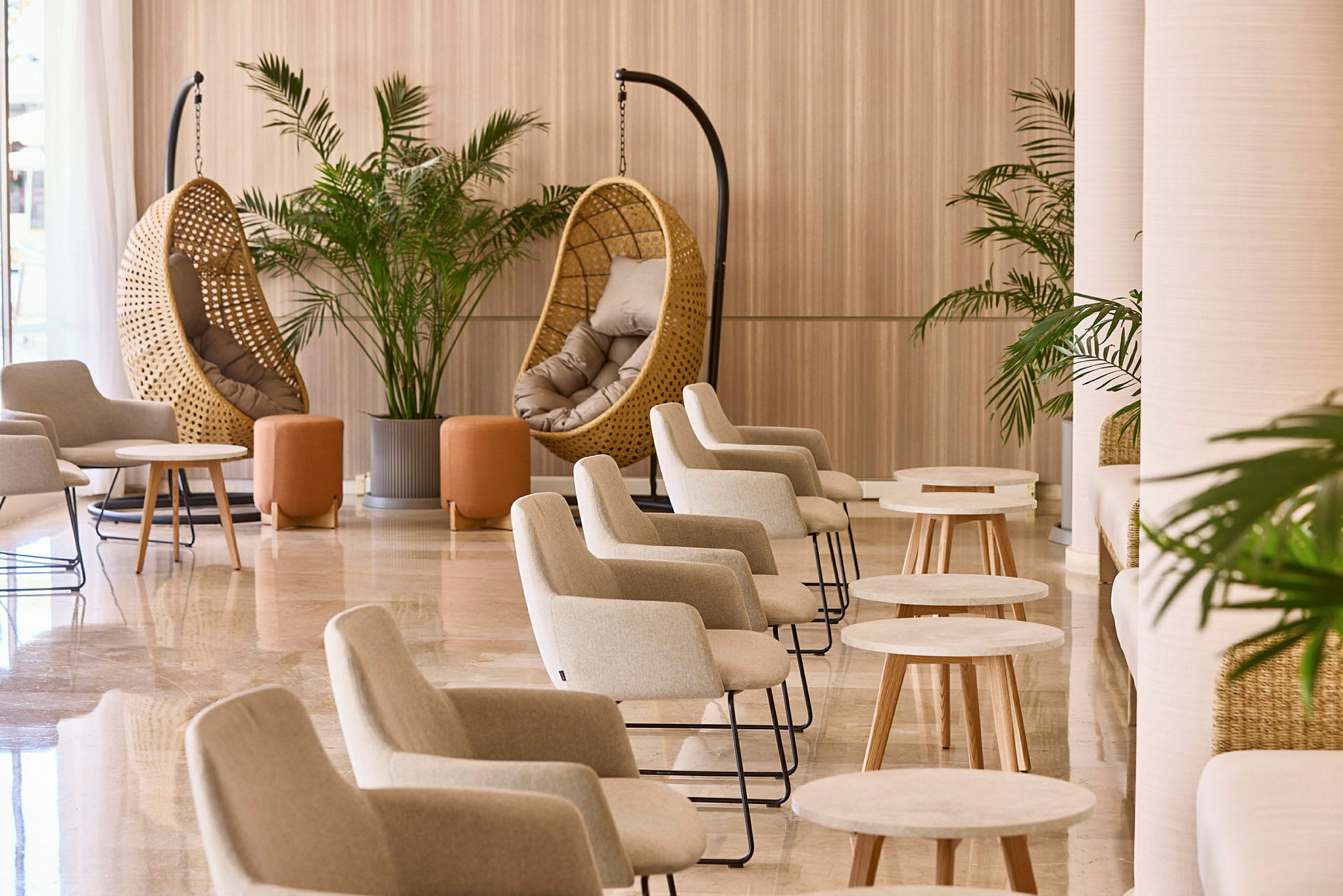 Inredning med flera stolar, bord och rottingstolar i en lounge. (AI-genererad text)