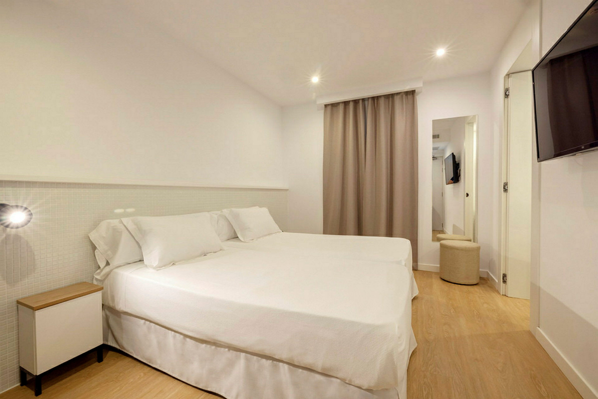 Ett hotellrum med två sängar täckta med vita sängkläder. (AI-genererad text)