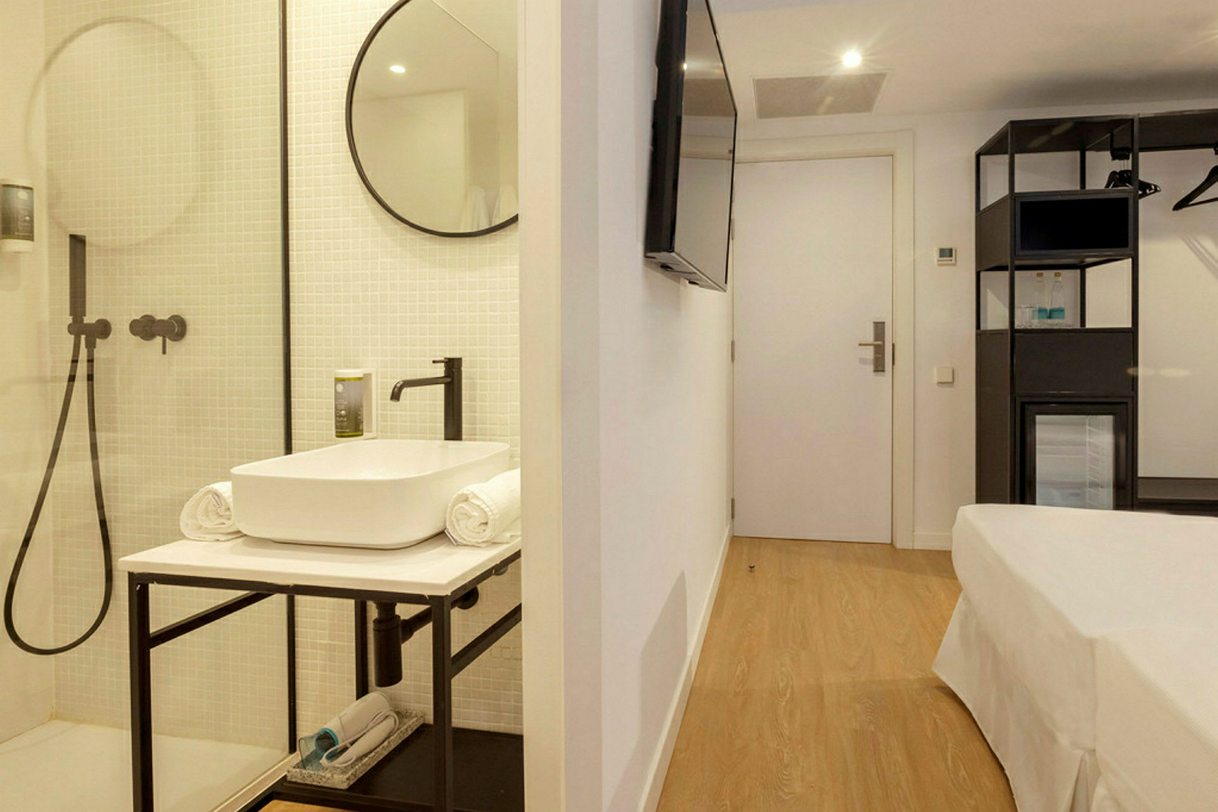 Ett hotellrum med modernt badrum och minimalistiska möbler. (AI-genererad text)