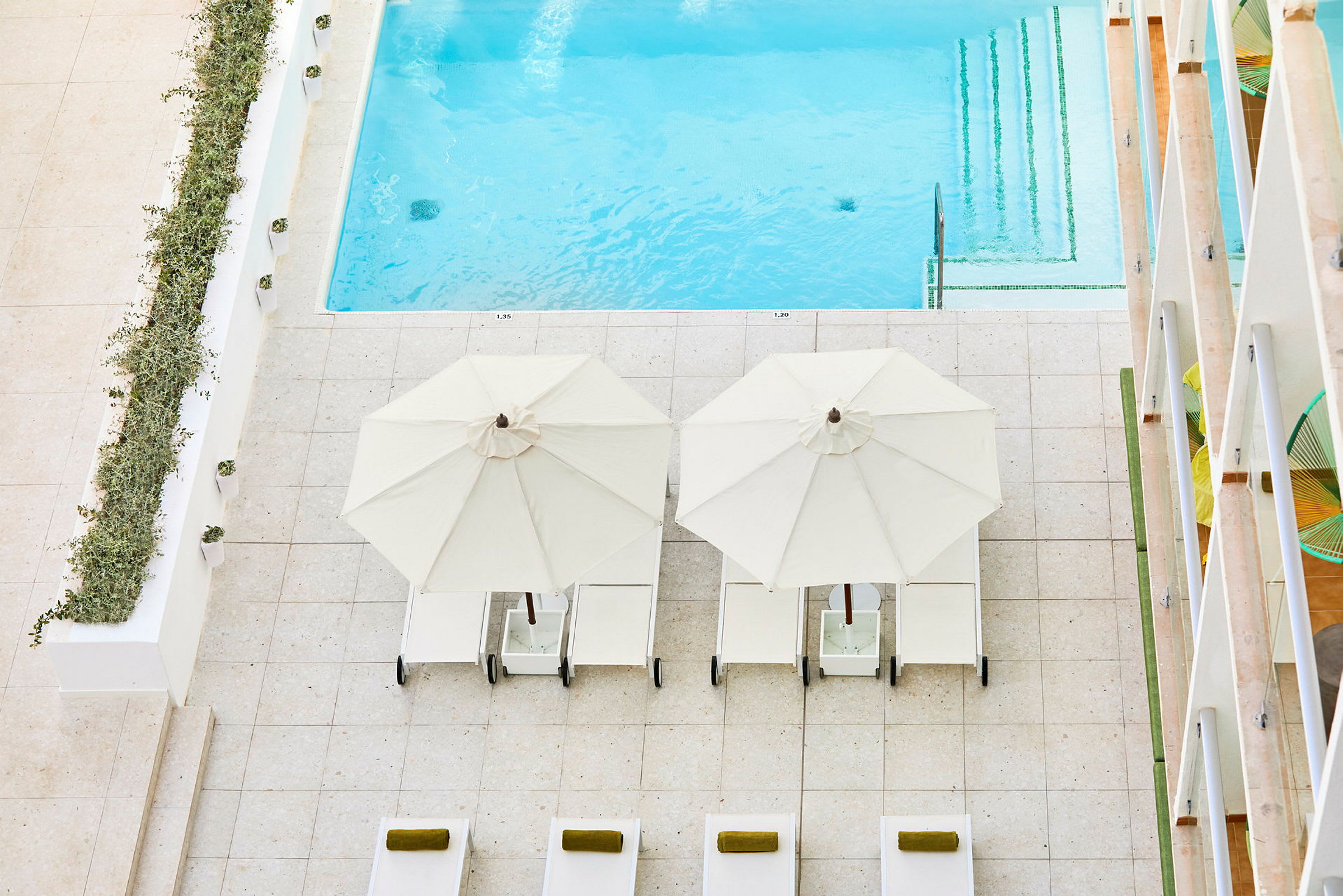Bild på en pool med solstolar och parasoll vid sidan. (AI-genererad text)