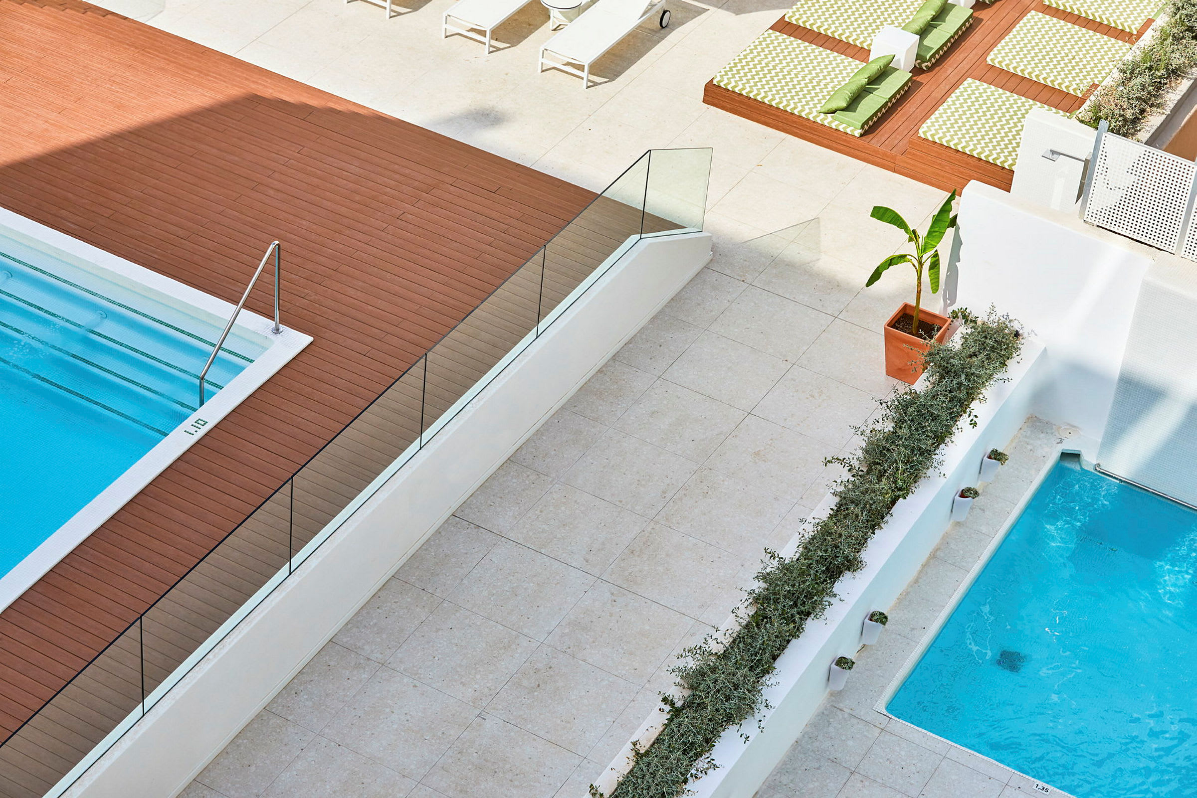 Bild på en modern poolområde med trädeck, solstolar och grönskande detaljer. (AI-genererad text)