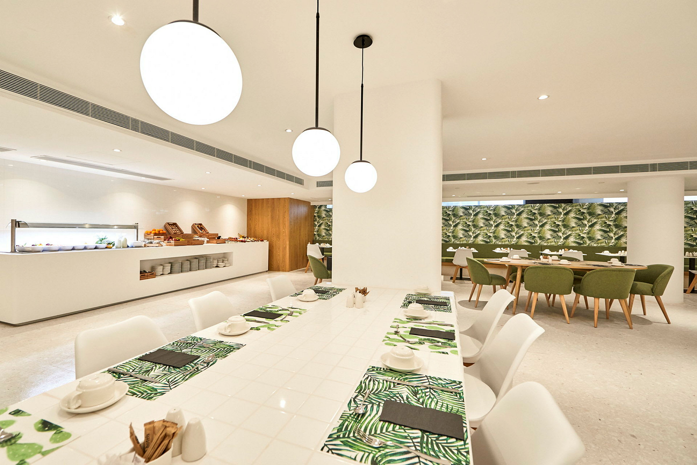 En stilren restaurang med vita möbler och gröna detaljer. (AI-genererad text)