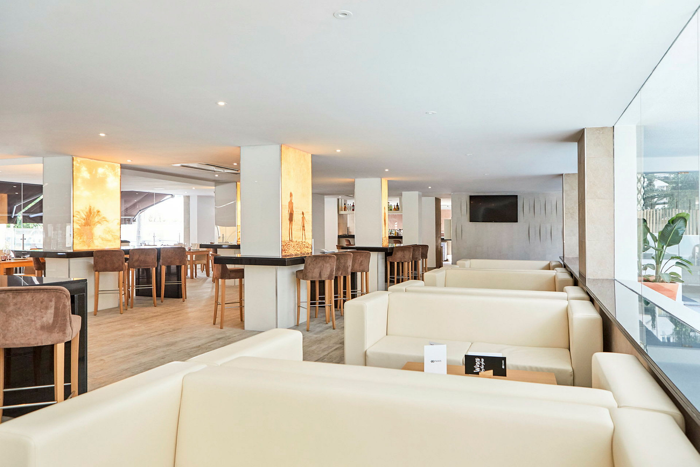 Bild av en modern restauranglounge med ljusa möbler och barmöbler. (AI-genererad text)