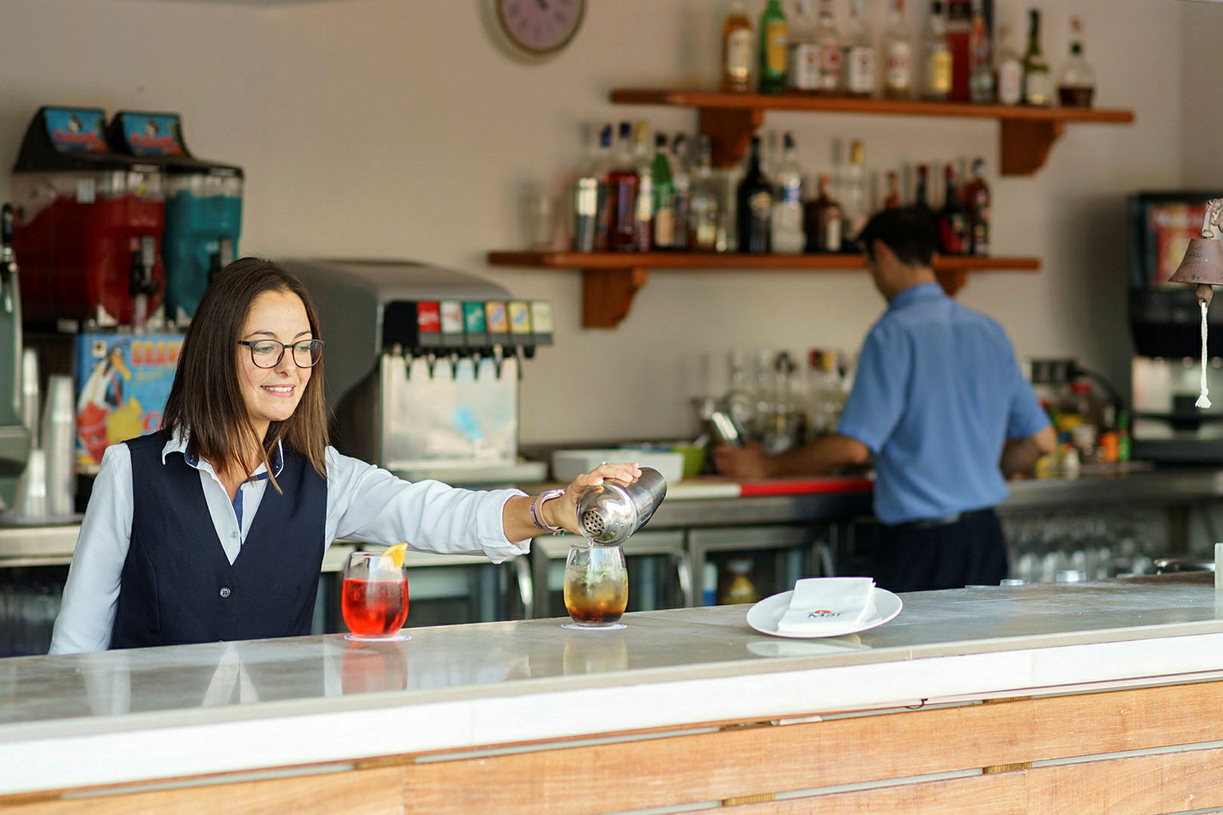 En bartender som häller drinkar vid en bardisk. (AI-genererad text)