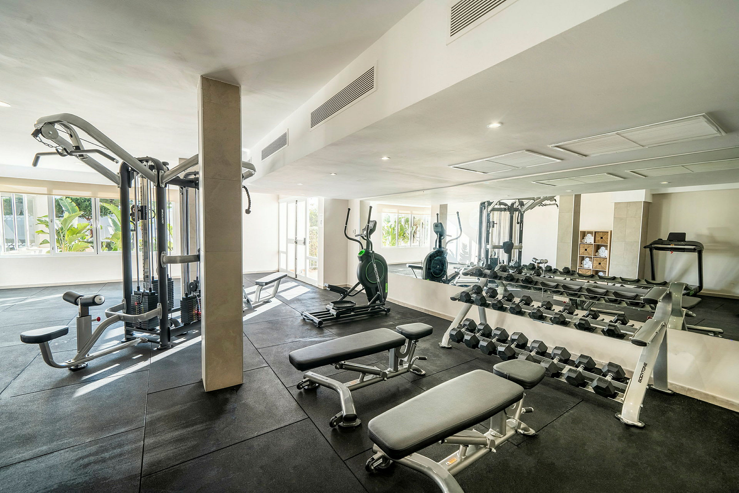 Ett gym med träningsmaskiner, vikter och bänkar. (AI-genererad text)