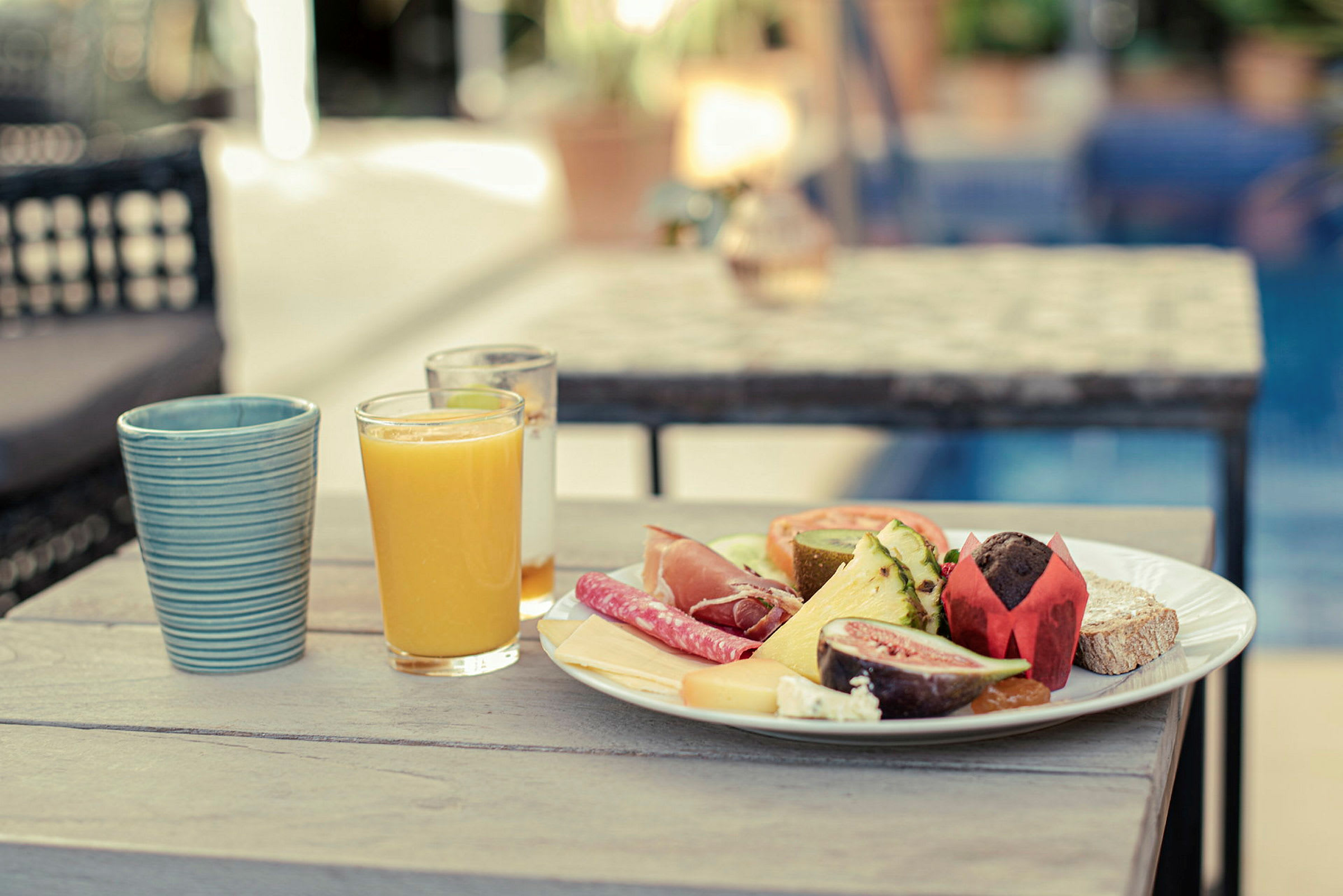 Frukostbord med ett glas apelsinjuice och tallrik fylld med olika matvaror. (AI-genererad text)