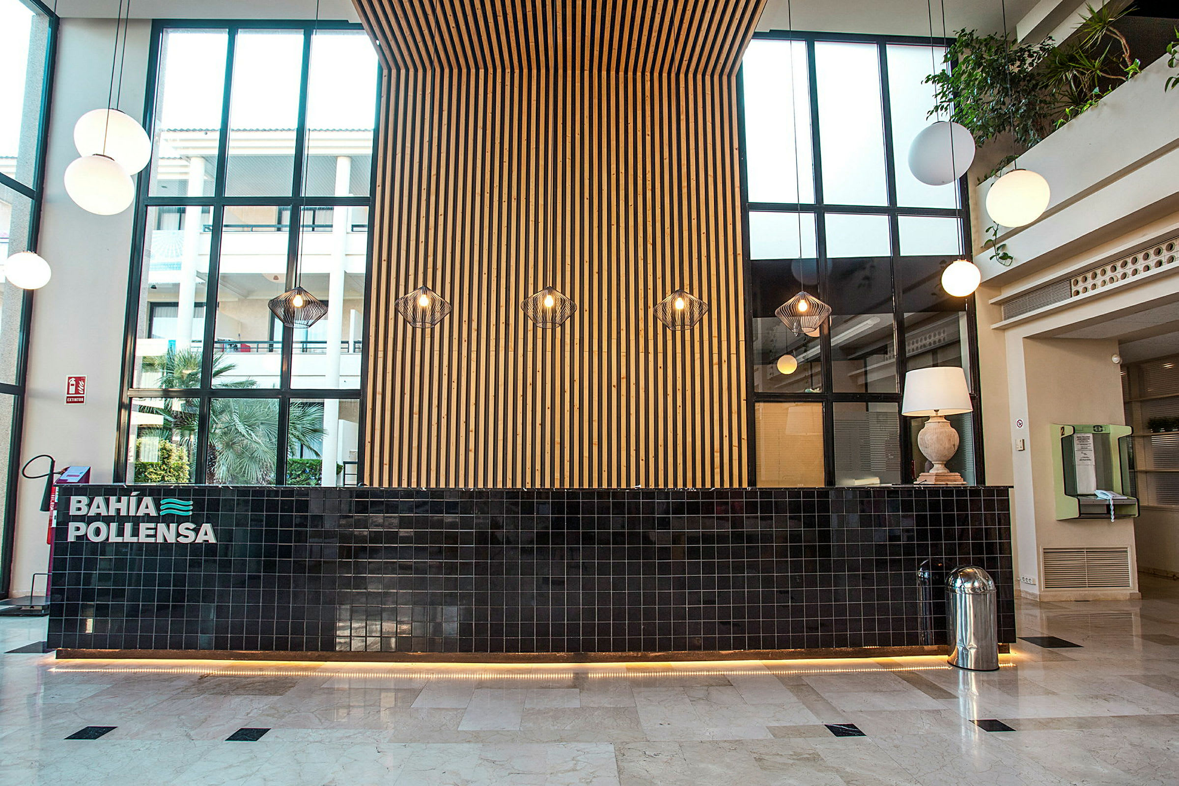 Receptionen på ett hotell med en modern inredning, en svart kaklad disk och en trävägg bakom. (AI-genererad text)