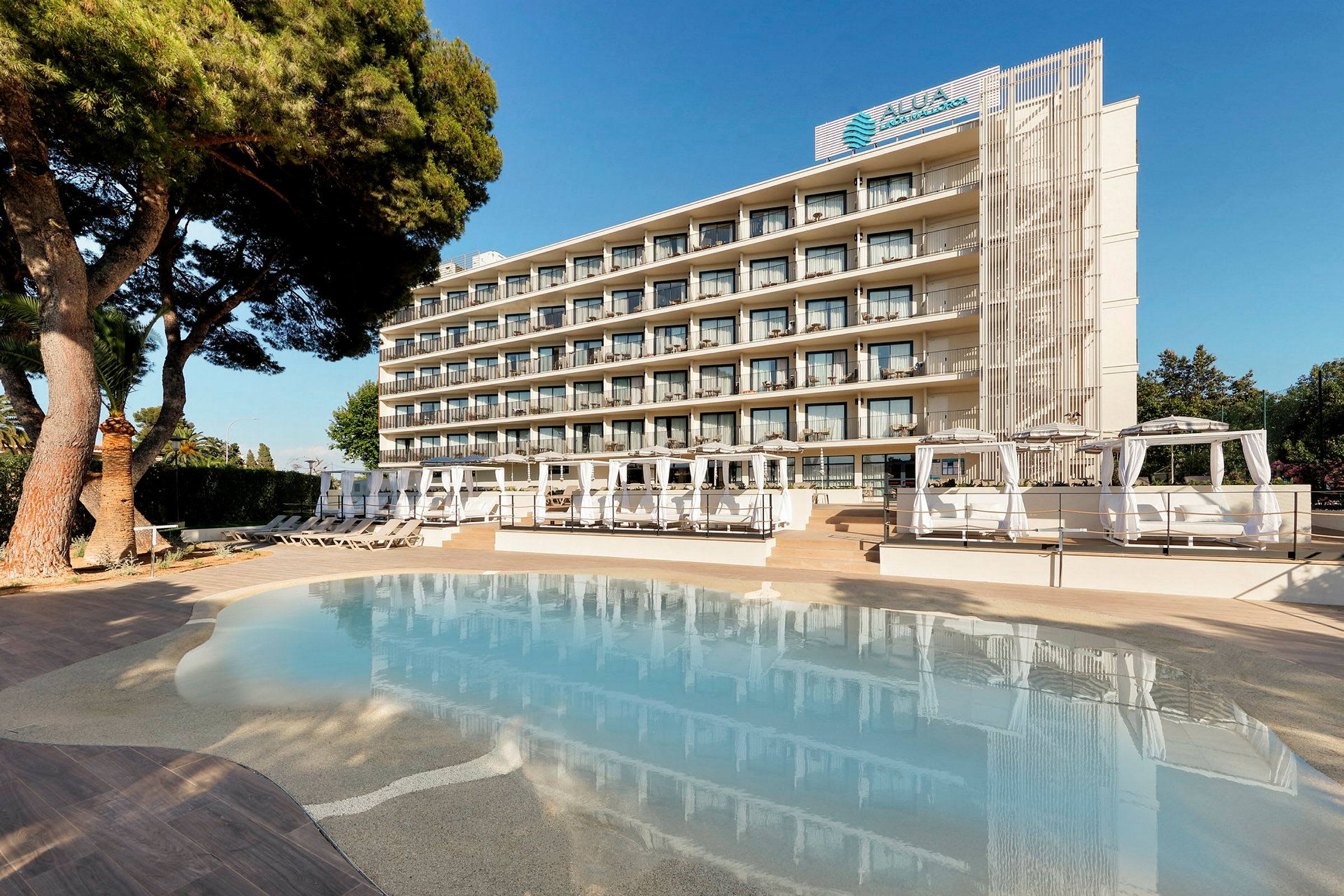 Ett hotell sett från poolområdet med solstolar och cabanas. (AI-genererad text)