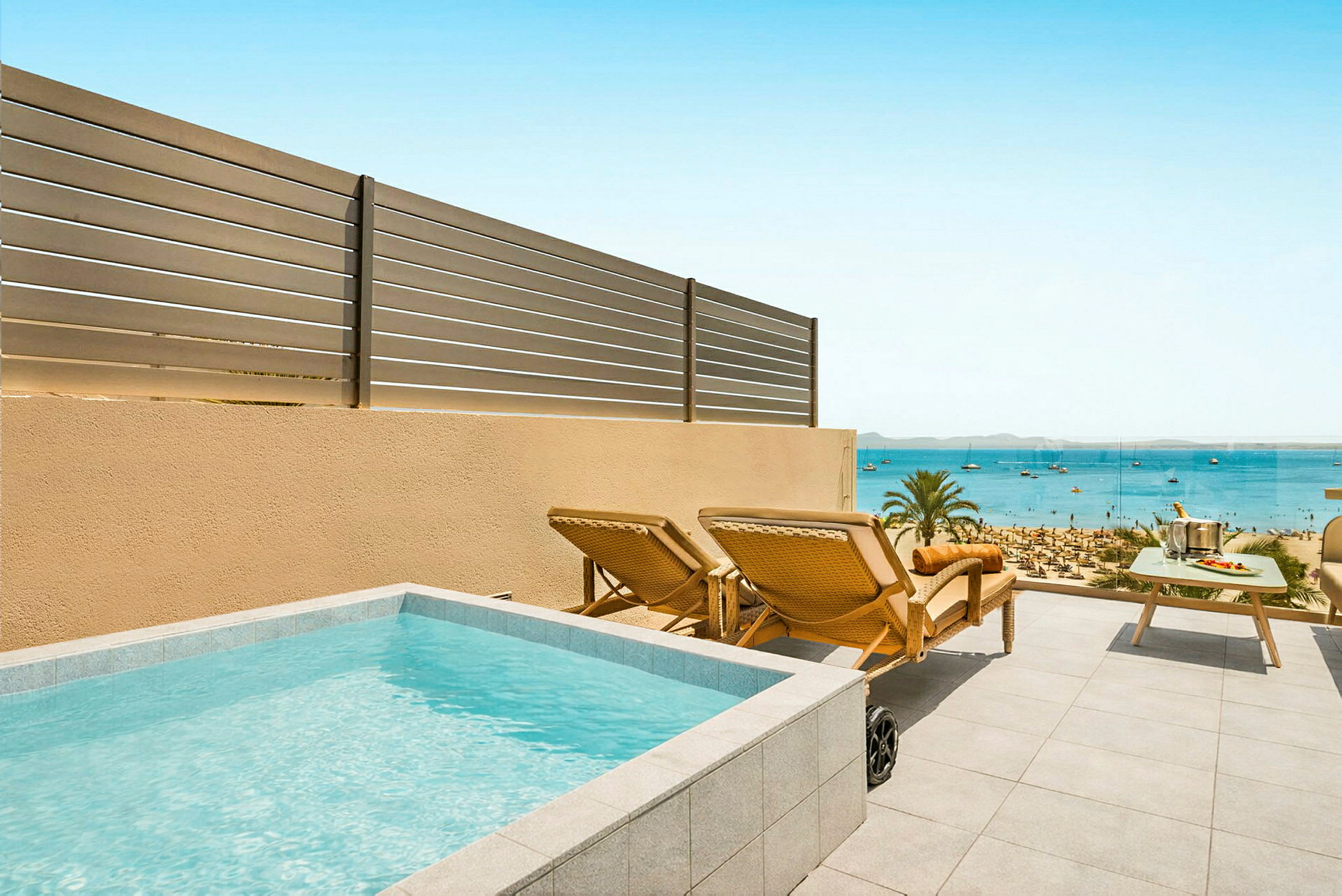 En terrass med liten pool, solstolar och ett bord med havsutsikt. (AI-genererad text)