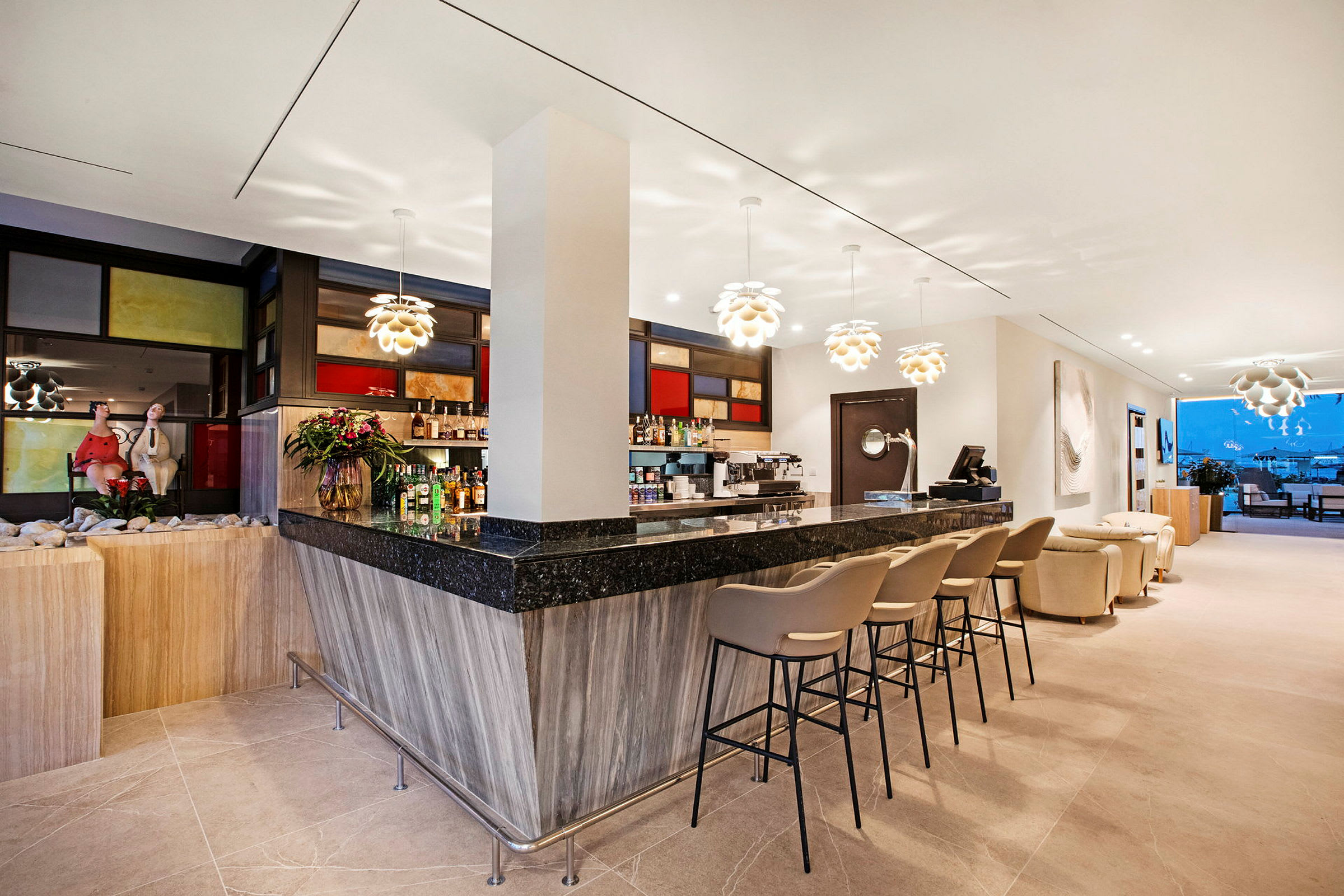 En modern bar med svarta och trämaterial, barstolar, dekorativa lampor och utsikt över en terrass med möbler i bakgrunden. (AI-genererad text)
