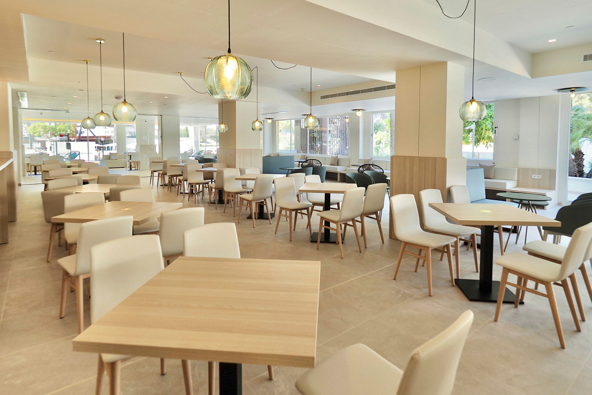 En modern och ljus inomhusrestaurang med trämöbler och dekorativa lampor. (AI-genererad text)