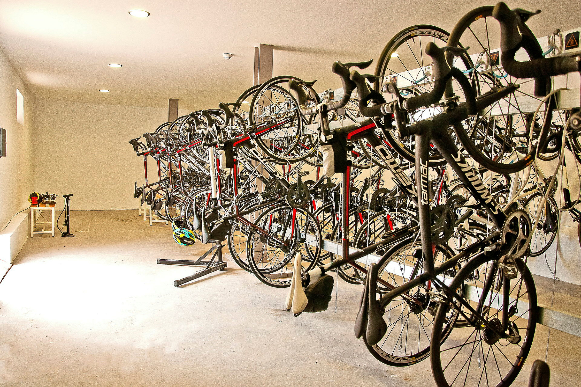 Bild av ett rum med flera cyklar som hänger sida vid sida på stativ. (AI-genererad text)