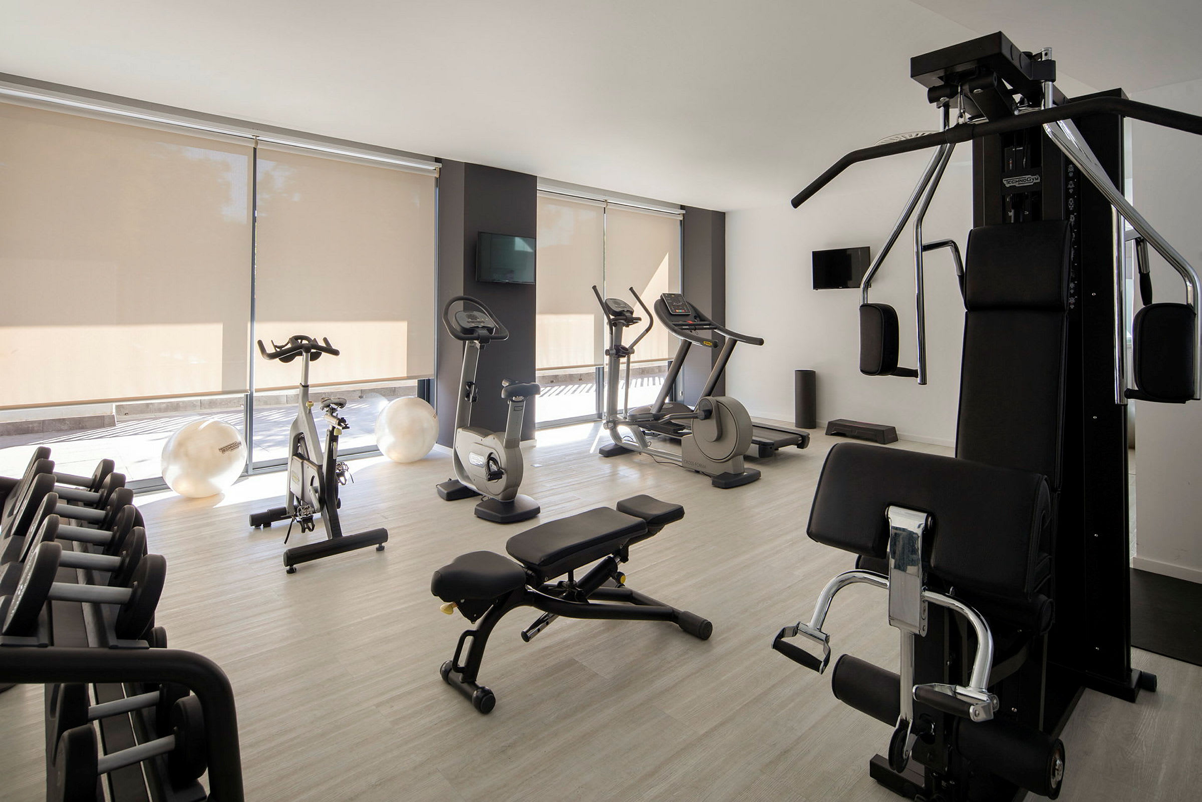 Ett modernt gym med olika träningsmaskiner, vikter och en bänk. (AI-genererad text)