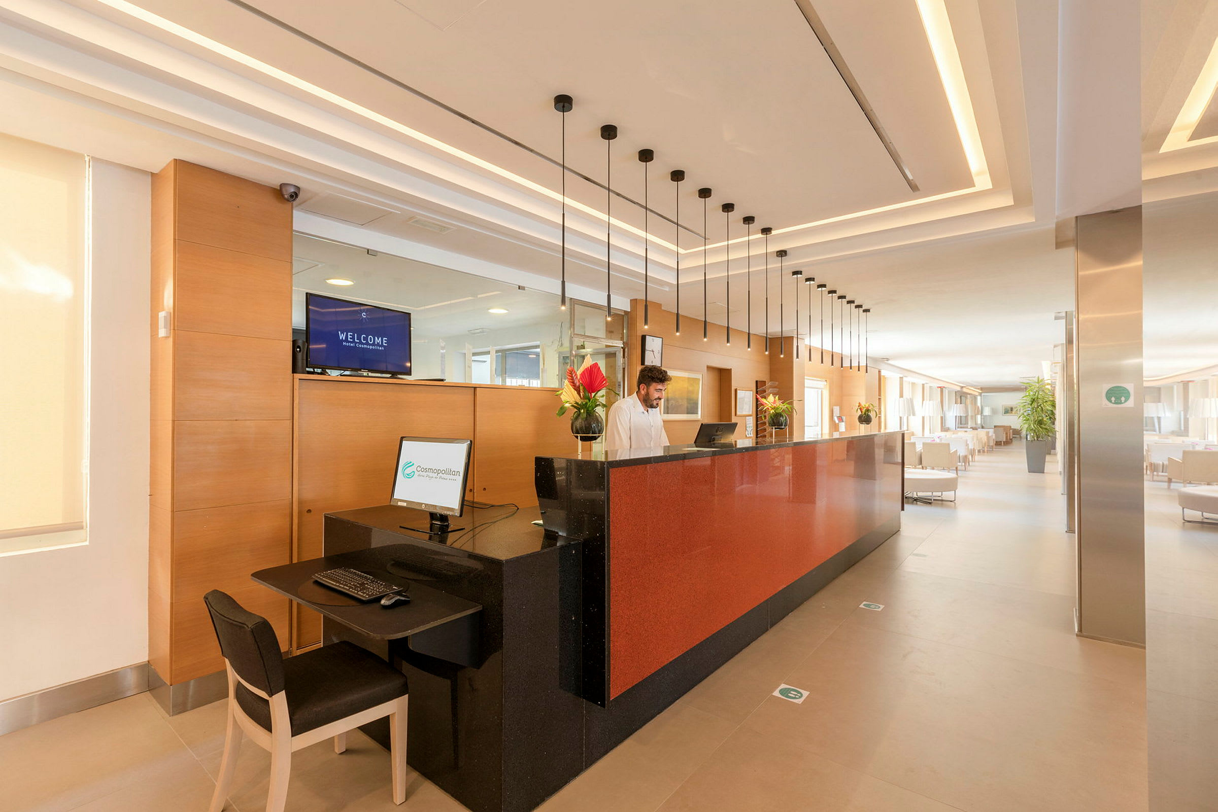 Hotellreception med en röd disk, datorskärm och dekorationer. (AI-genererad text)