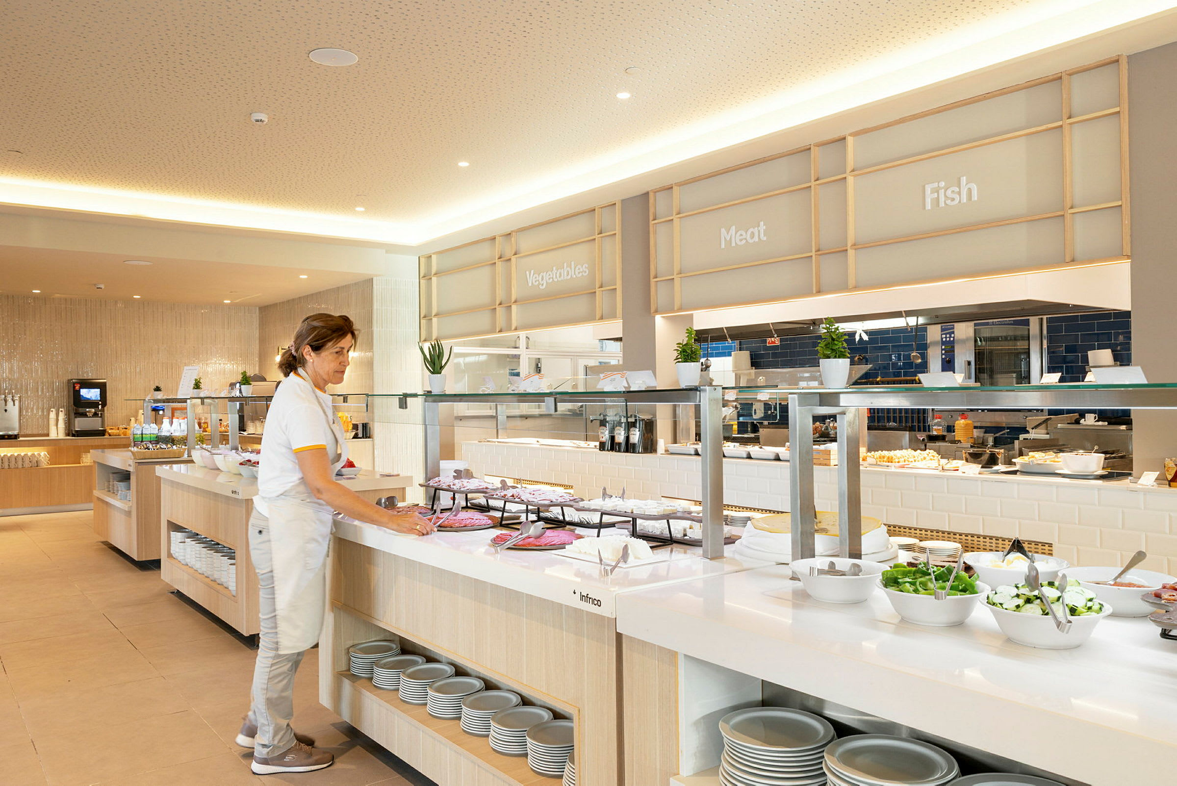 Bufféområde med olika matalternativ, organiserade under skyltar för grönsaker, kött och fisk. (AI-genererad text)