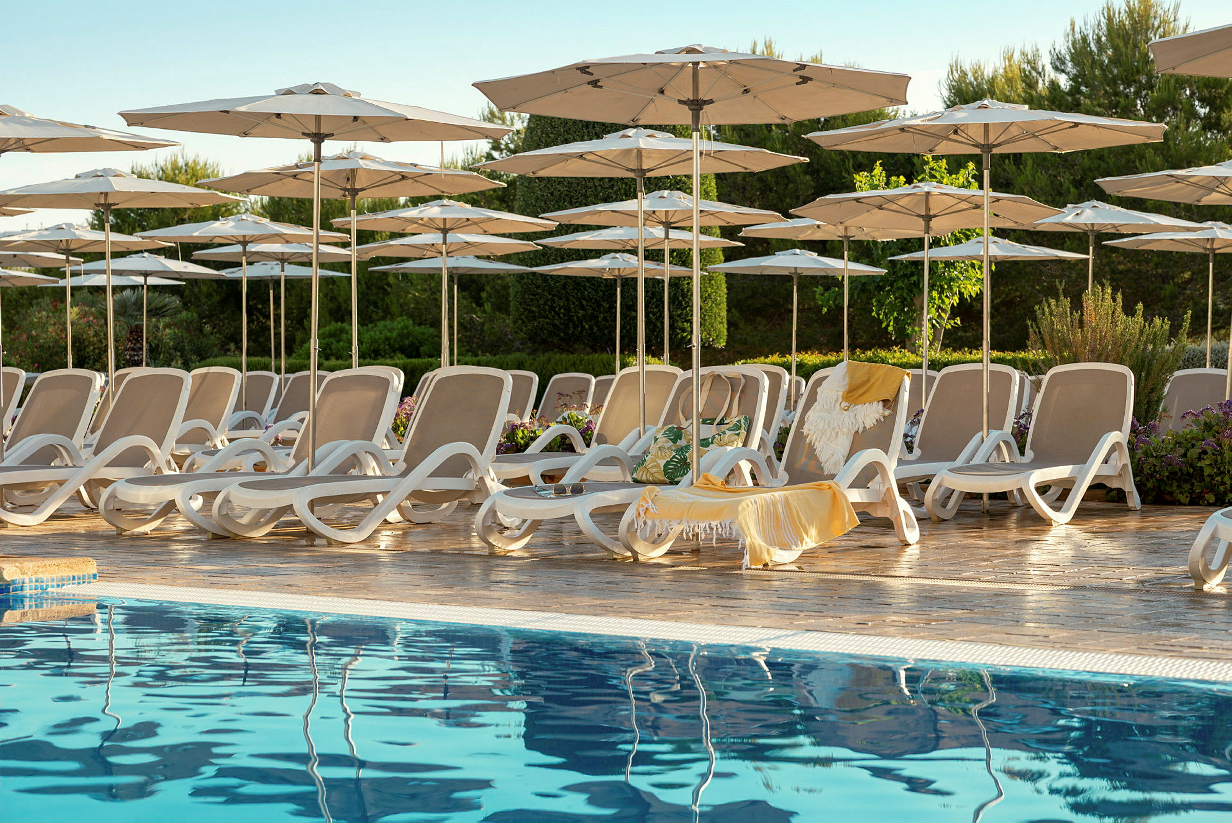 Solstolar och parasoller vid en pool. (AI-genererad text)