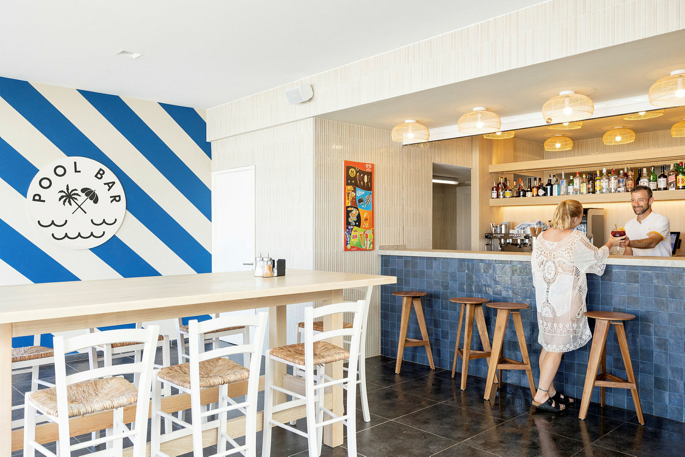Bild av en poolbar med blå och vita diagonala linjer på väggen och sittplatser vid bardisken och bord. (AI-genererad text)