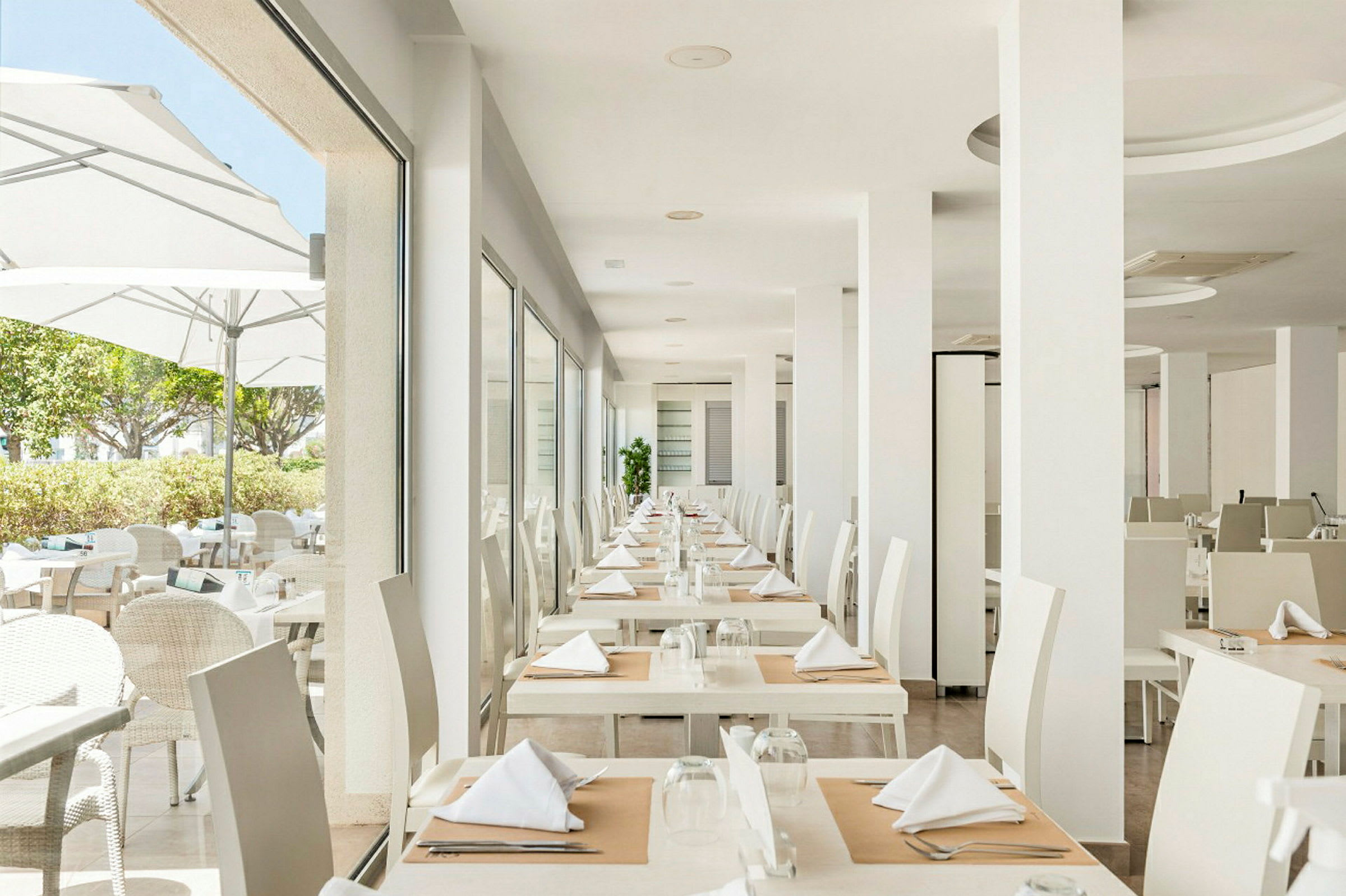 En modern och ljus restaurang med dukade bord i en organisering. (AI-genererad text)