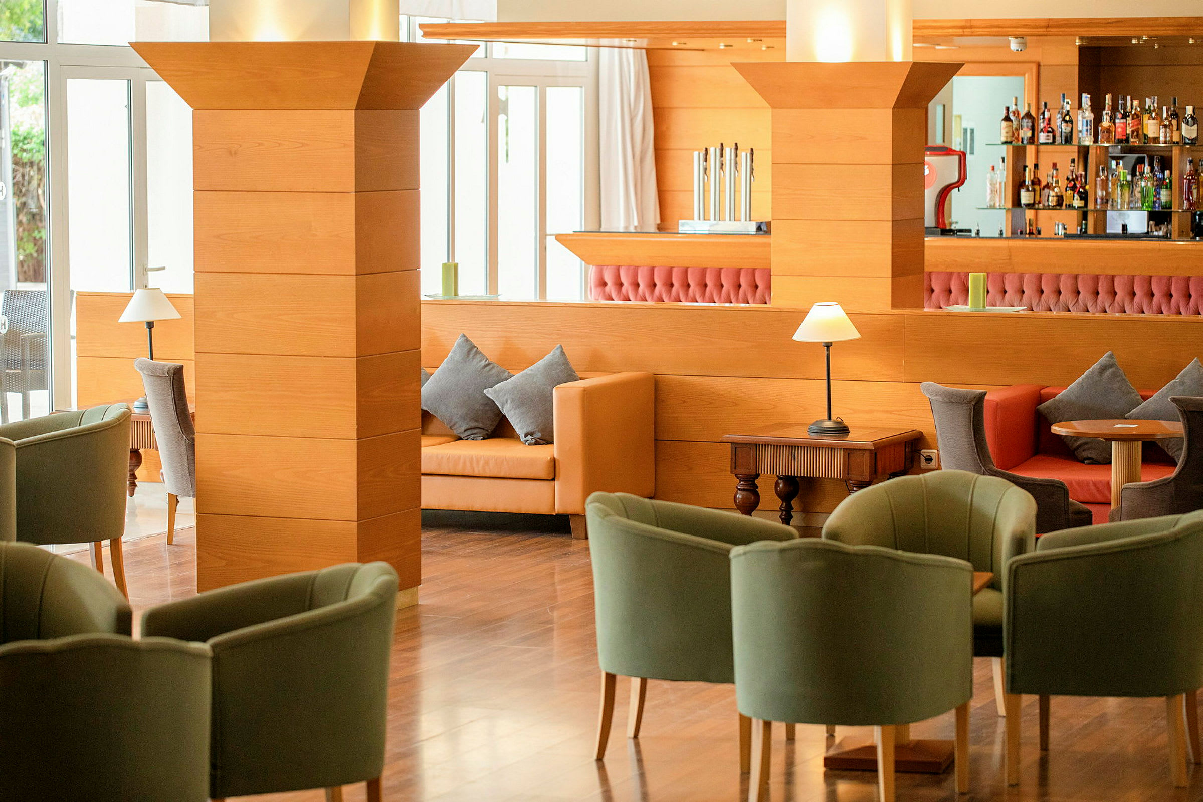 Interiör av en hotellets lounge med bekväma sittplatser, träinredning och en bar i bakgrunden. (AI-genererad text)