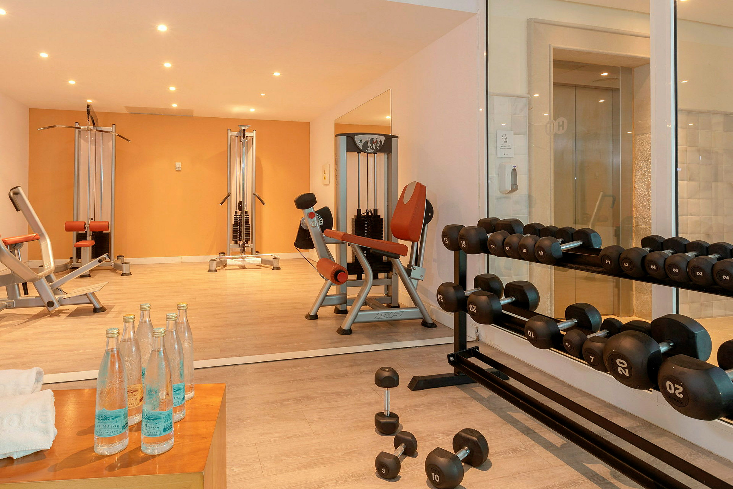 Ett gym med träningsmaskiner, hantlar och vattenflaskor. (AI-genererad text)
