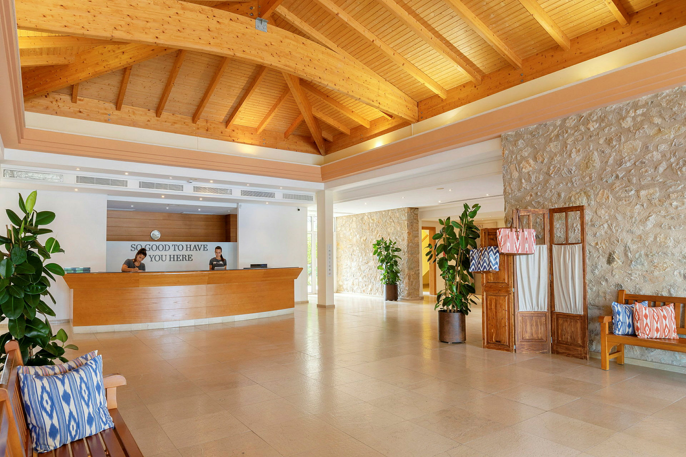 Hotellreception med träpanel och välkomstskylt. (AI-genererad text)