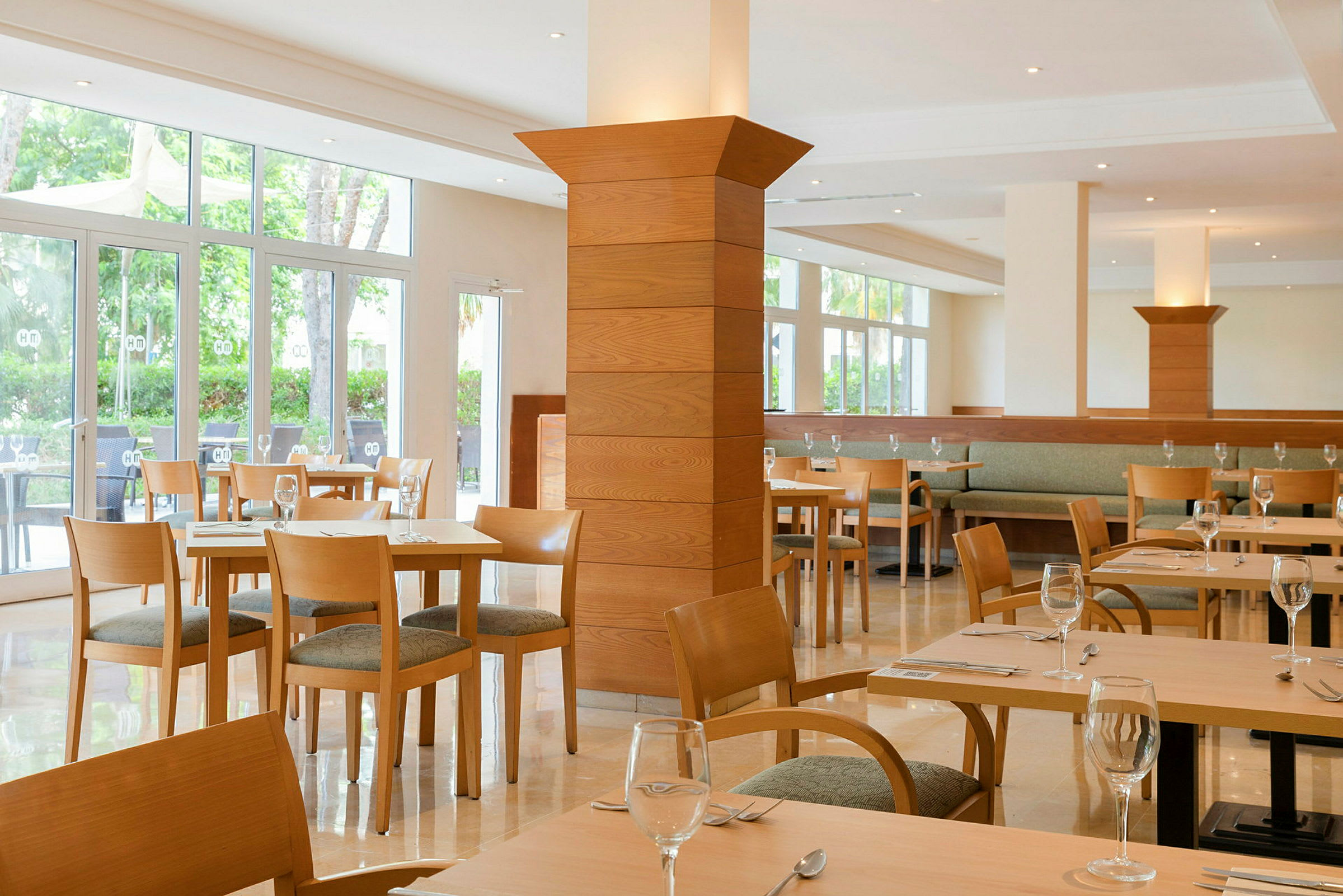 Ljusa restaurangmöbler med glasväggar och trädetaljer. (AI-genererad text)