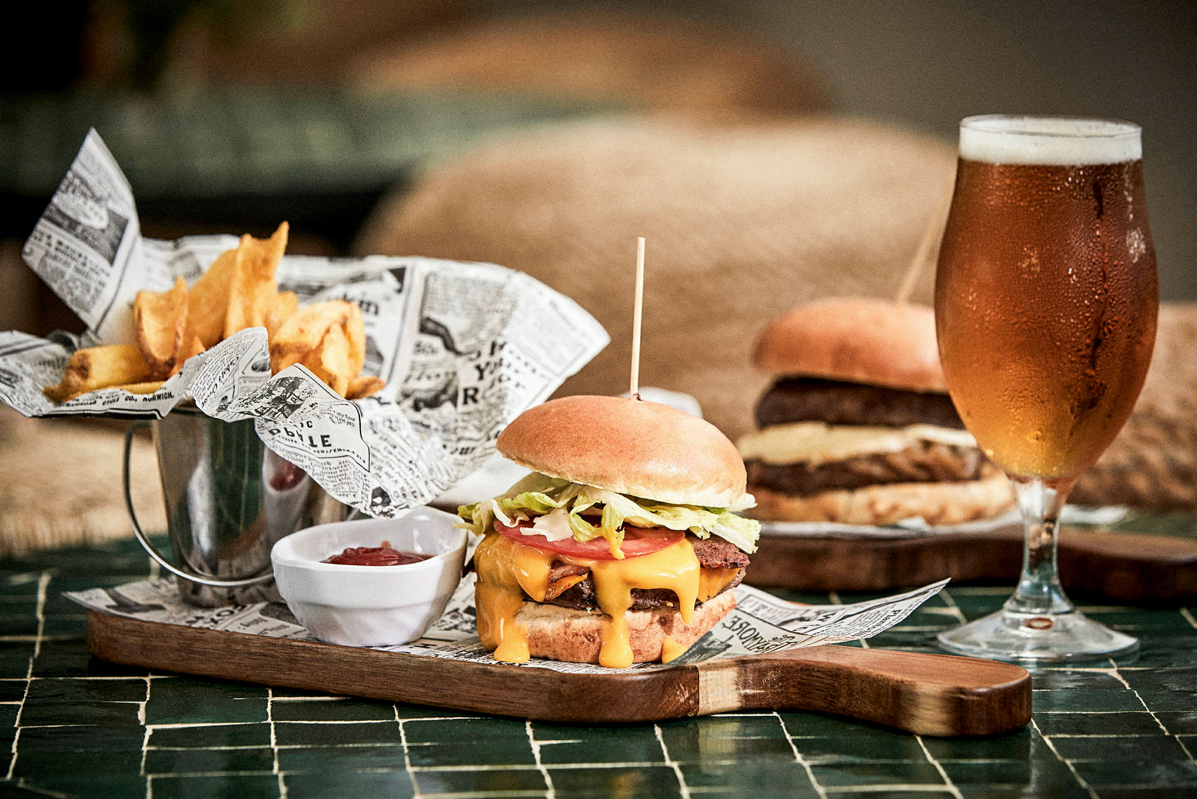 Bild på en hamburgertallrik med pommes frites, ketchup och glas öl. (AI-genererad text)