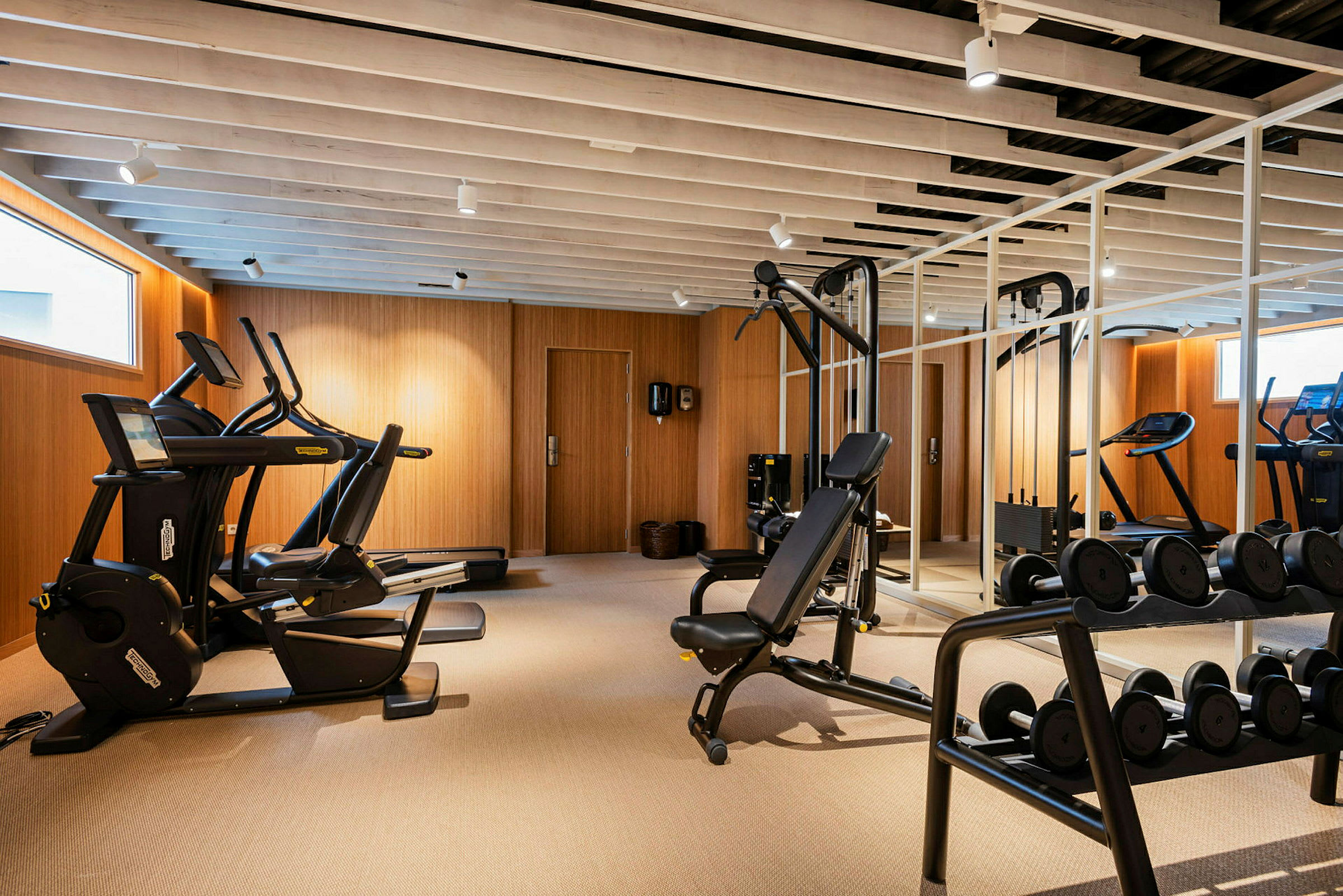 Ett modernt gym med träningsmaskiner och fria vikter. (AI-genererad text)