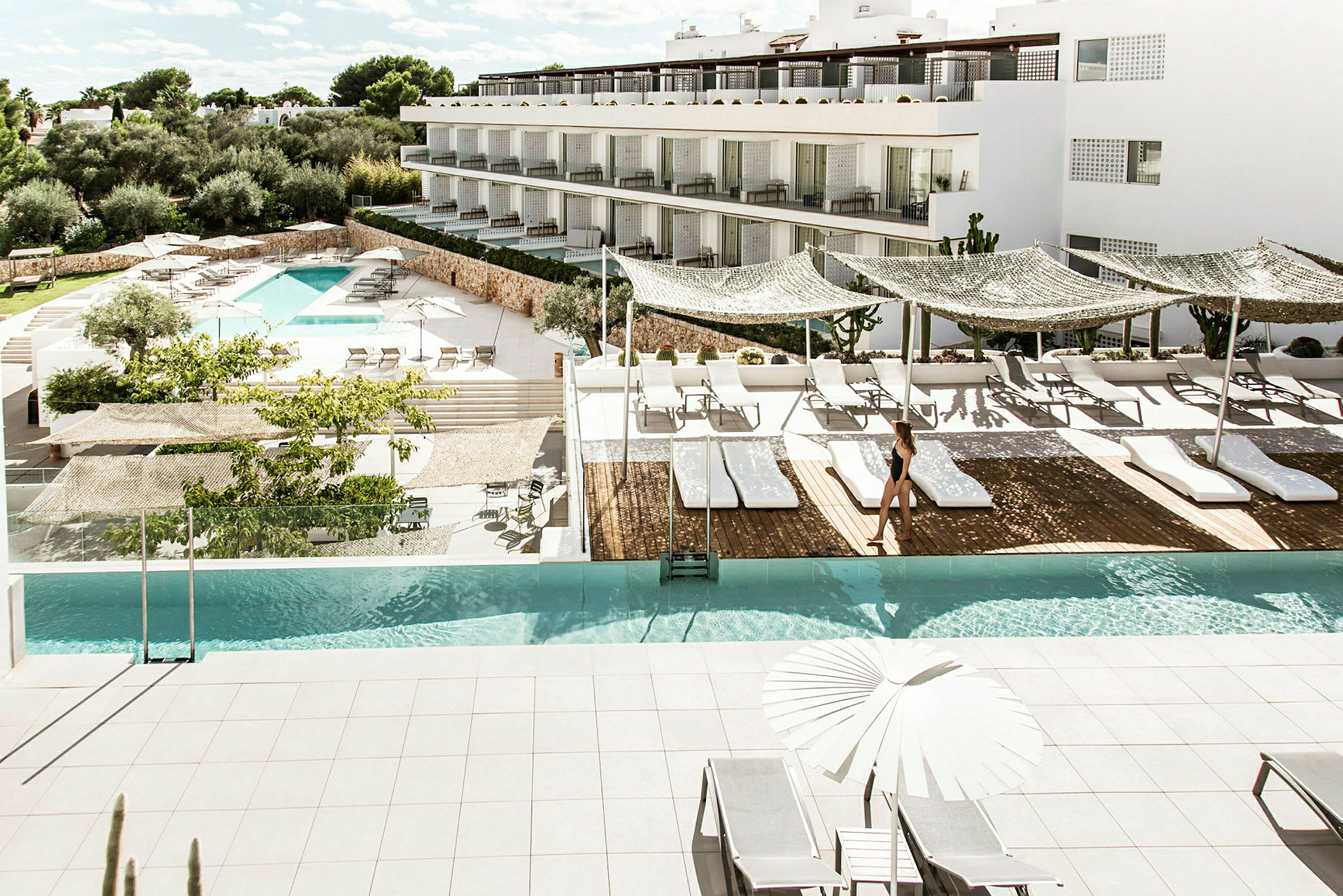 En modern hotellpool med solstolar och parasoller på en solig terrass. (AI-genererad text)