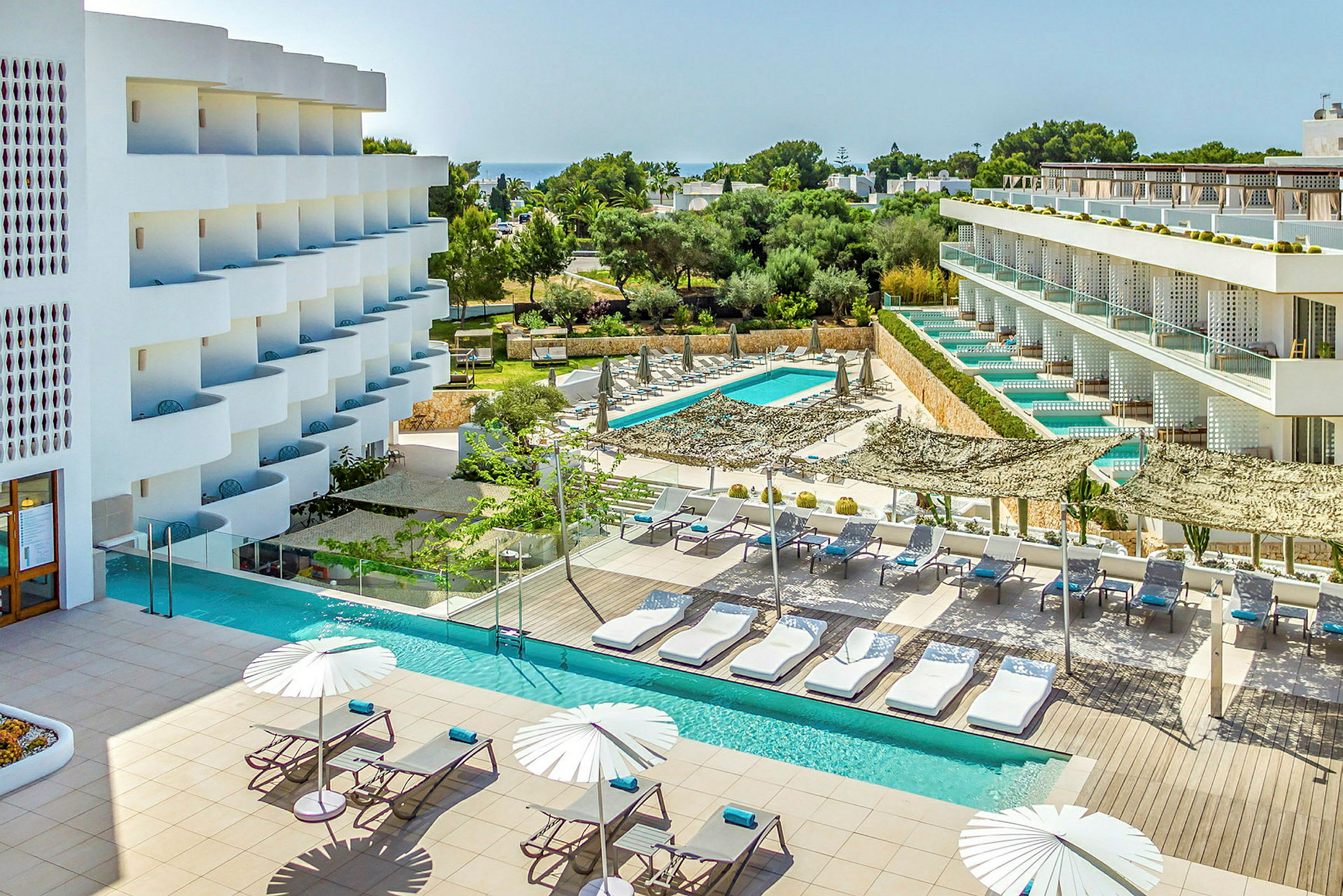 Ett modernt hotell med poolområde och solstolar. (AI-genererad text)