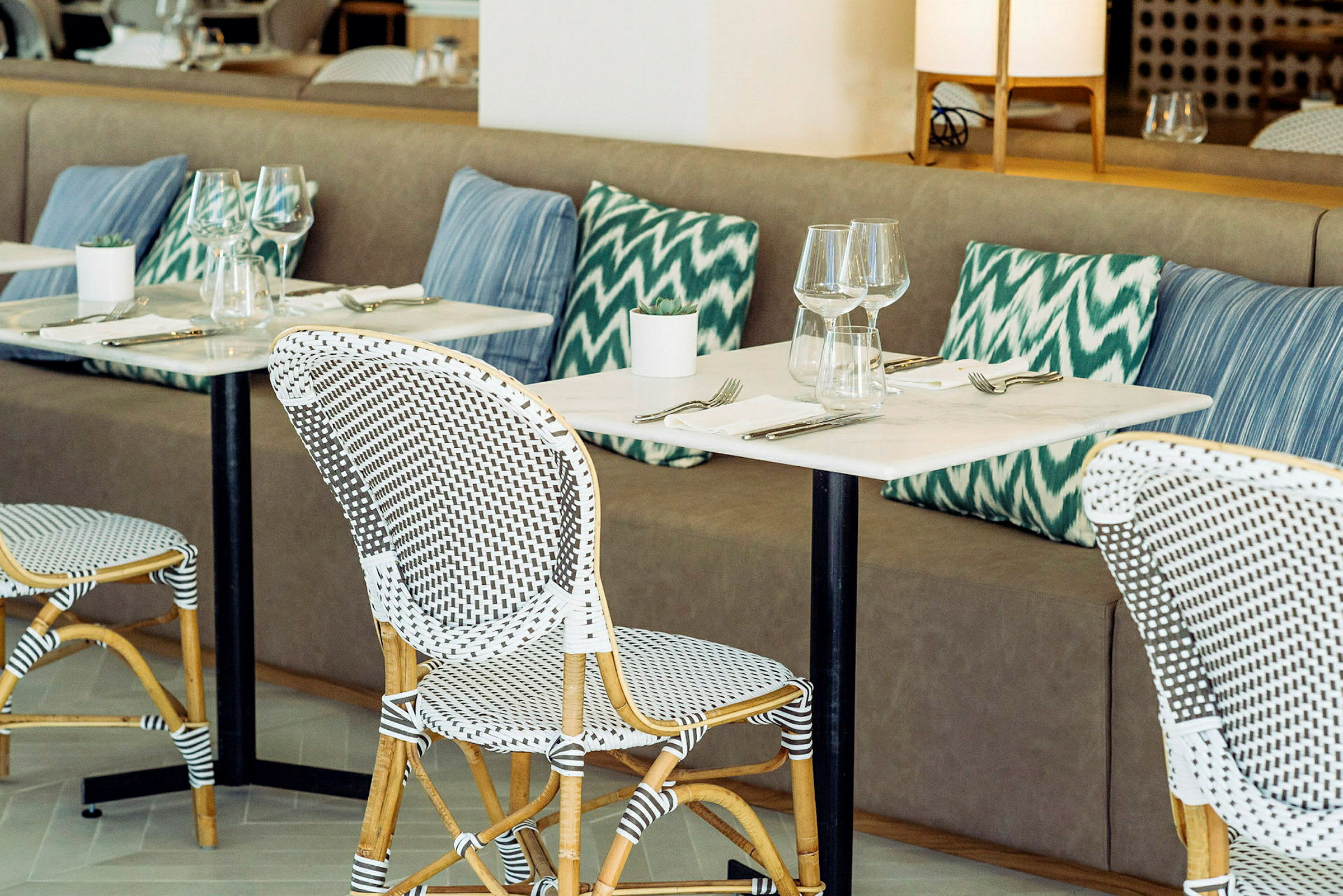 Restaurang med bordsuppsättning och kuddar. (AI-genererad text)