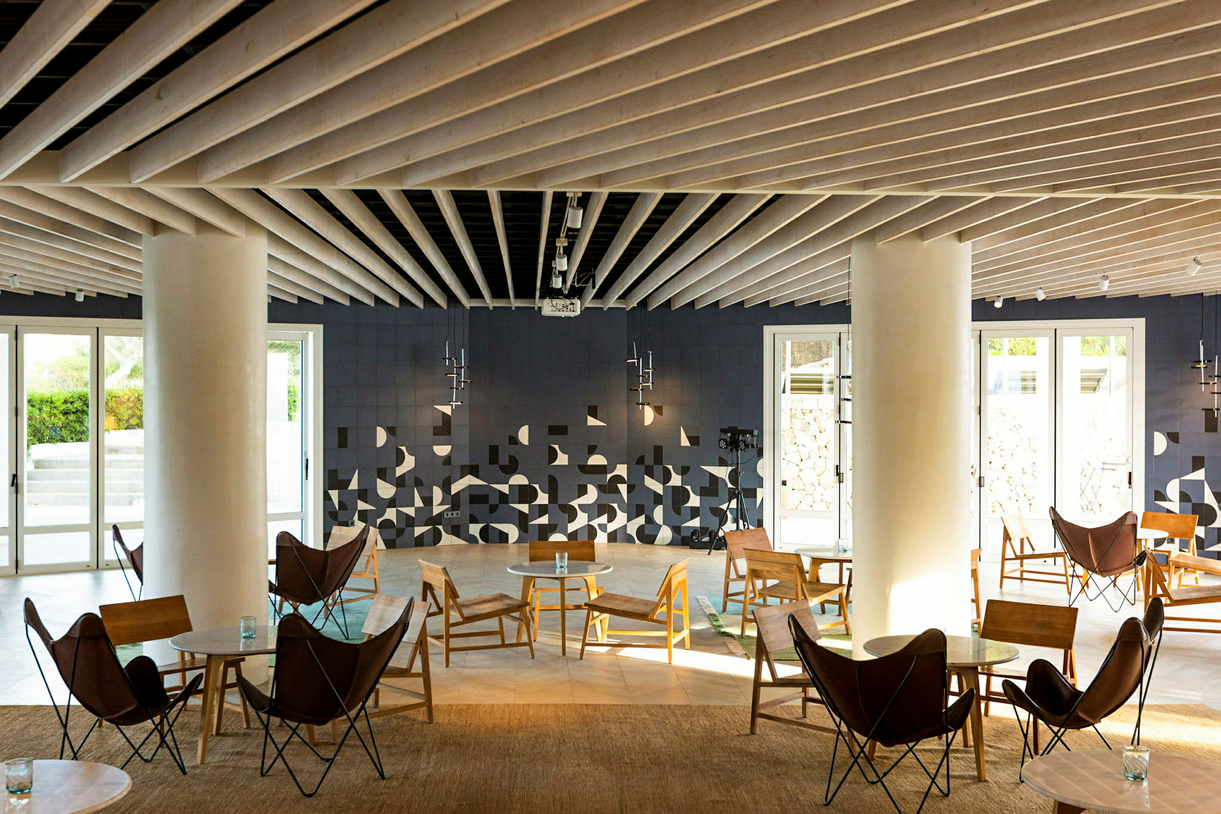 En modern loungemiljö med sittmöbler och geometriska dekorationer på väggen. (AI-genererad text)