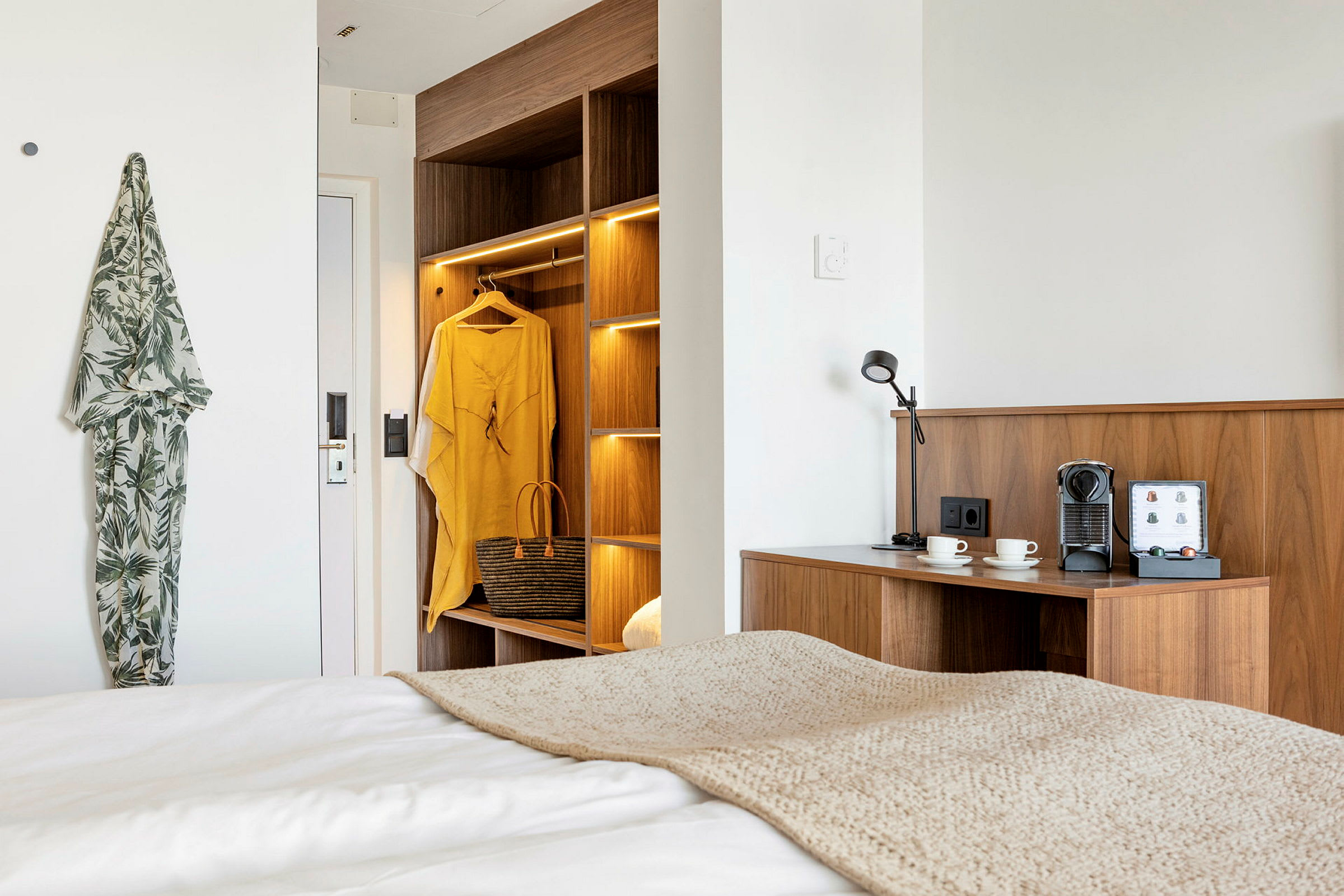Modernt hotellrum med träinredning, kaffestation och belysning. (AI-genererad text)