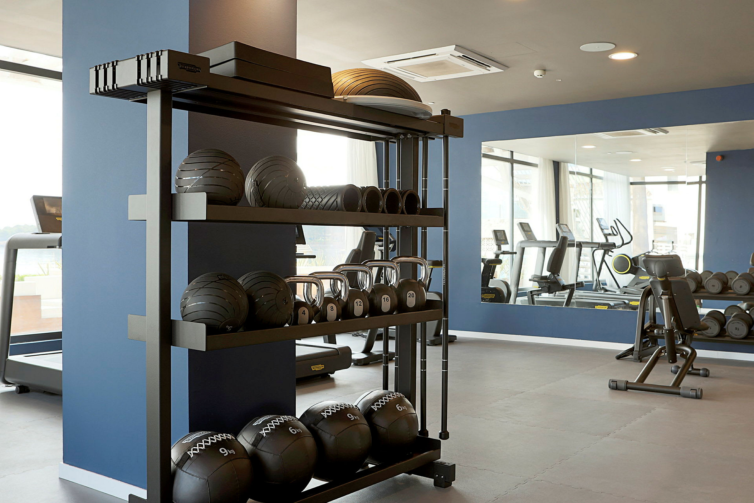 Bild av ett gym med utrustning inklusive bollar och vikter. (AI-genererad text)