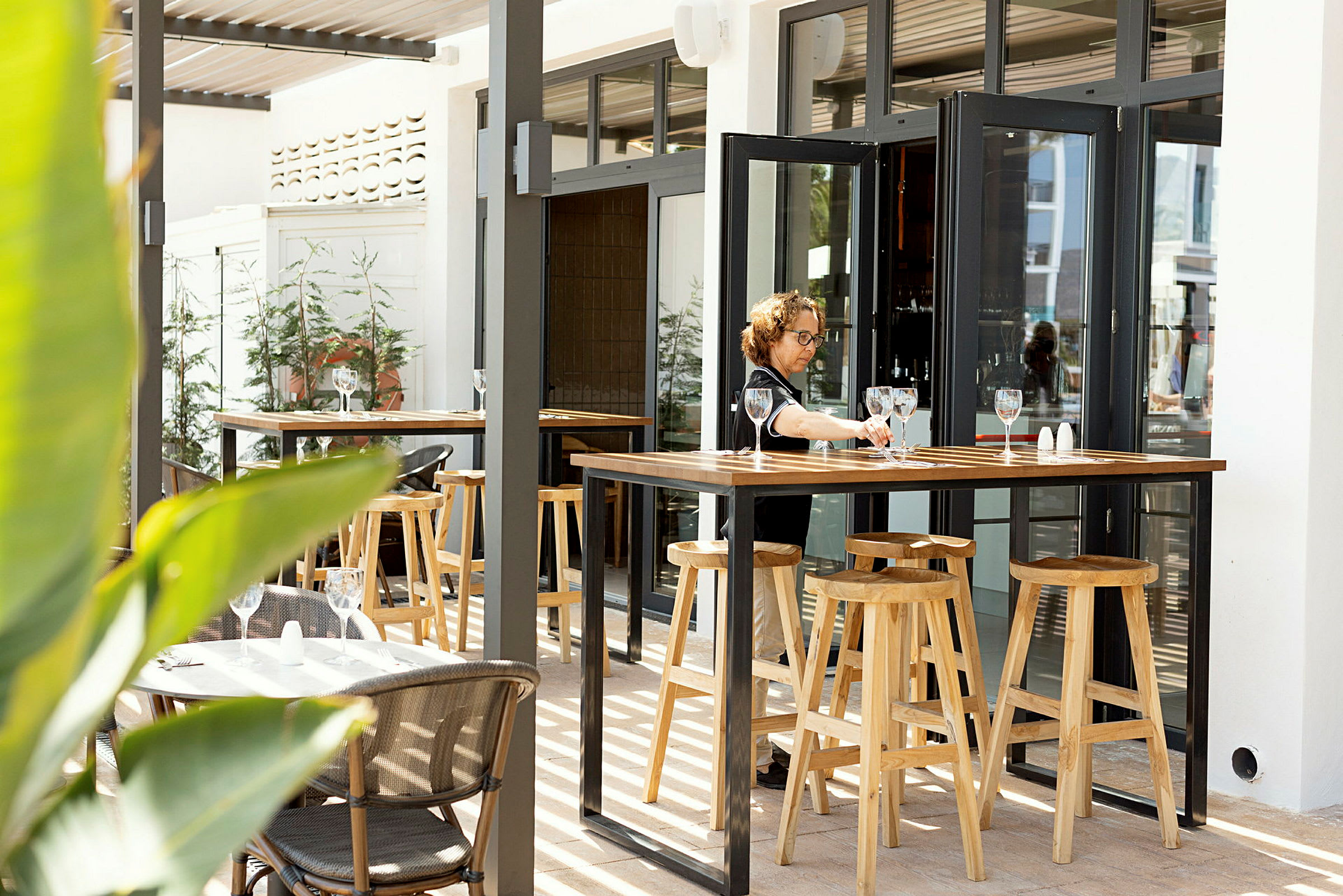 En utomhusrestaurang med bord och höga träpallar. (AI-genererad text)