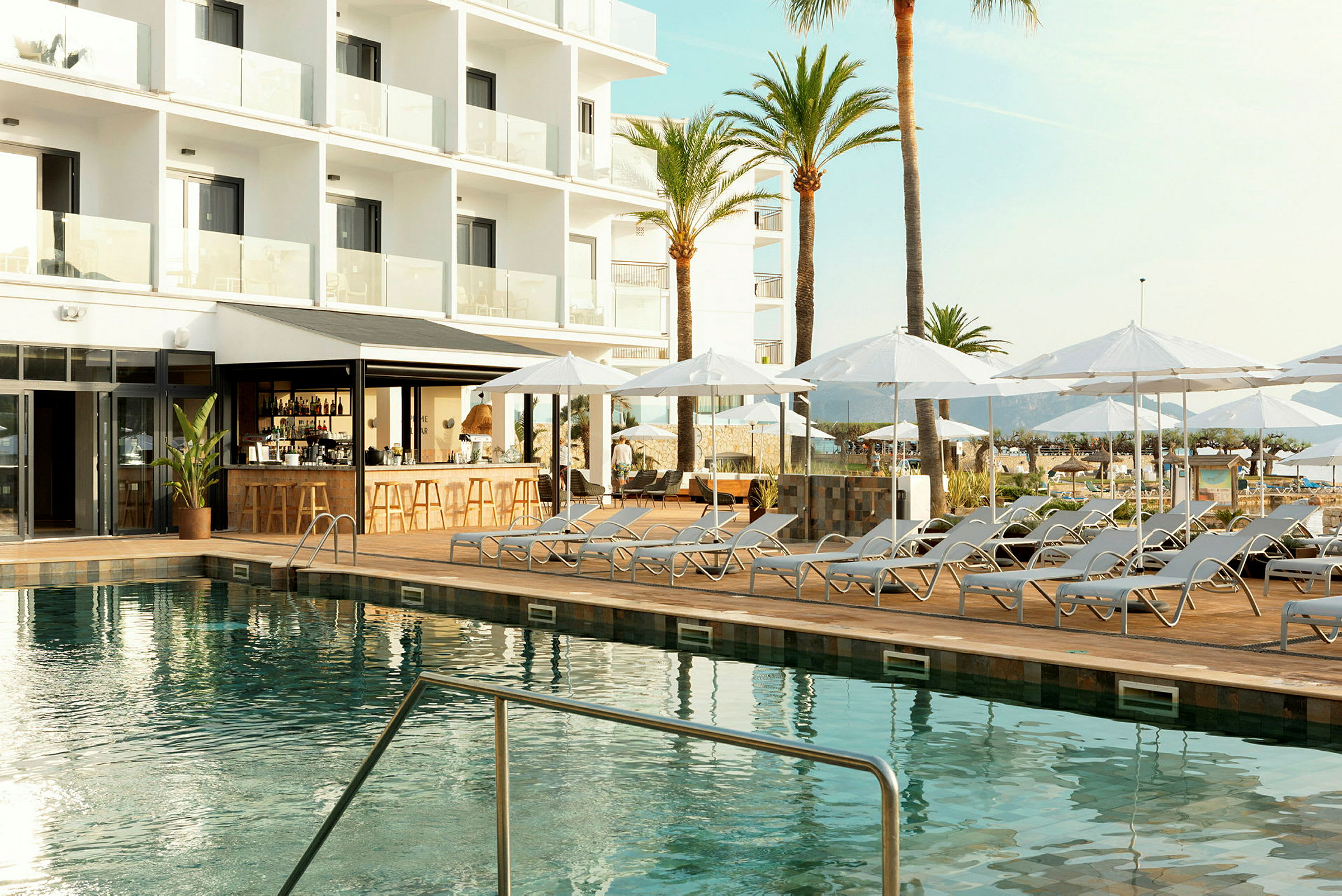 Utomhuspool med solstolar och parasoll vid ett modernt hotell. (AI-genererad text)