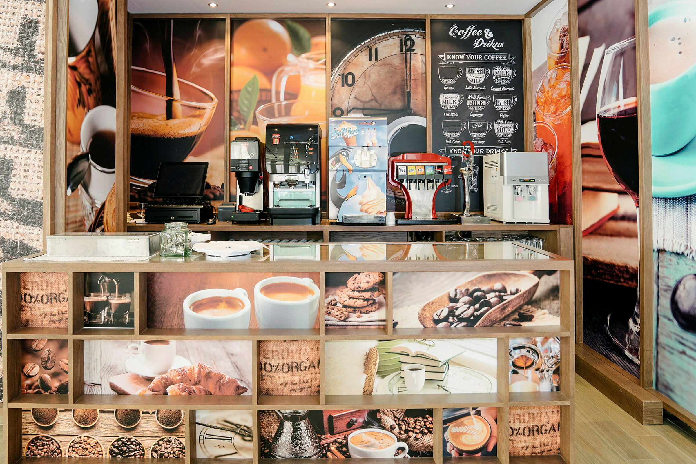 En kafédisk med kaffemaskiner och dekorativa bilder på kaffe och tillbehör. (AI-genererad text)