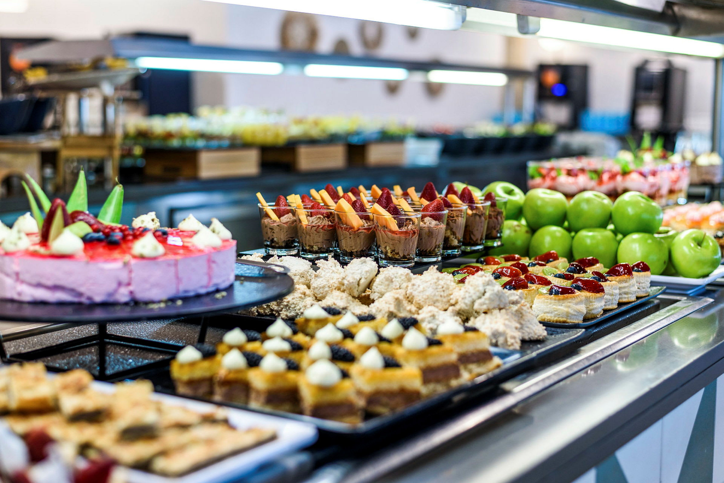 Buffé med olika desserter, kakor och gröna äpplen. (AI-genererad text)