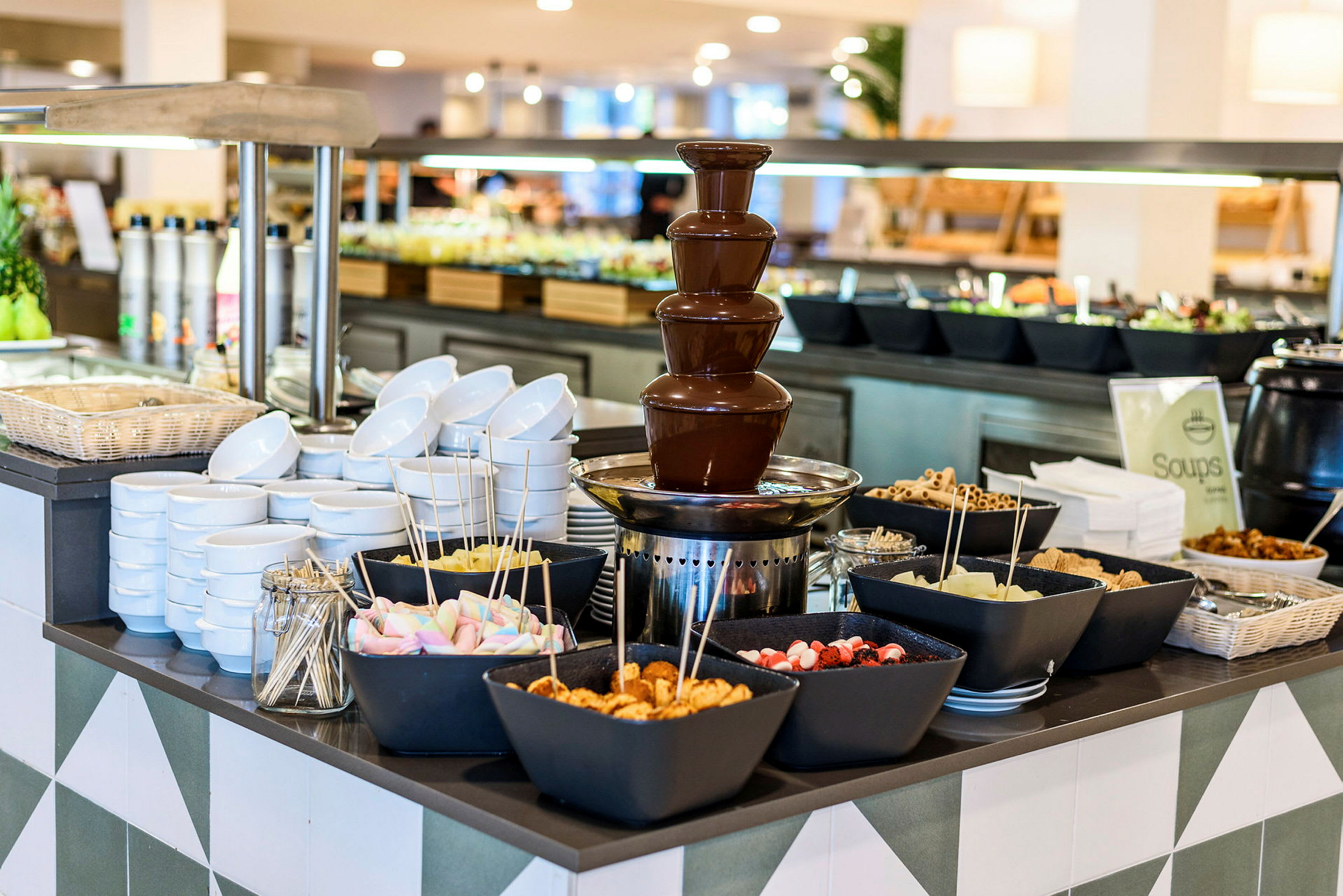 En buffé med en chokladfontän och skålar fyllda med olika tillbehör. (AI-genererad text)