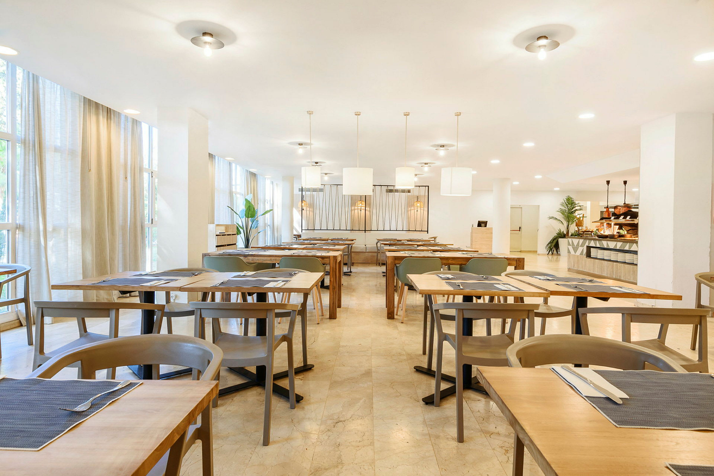 En ljust inredd restaurang med uppställda bord och stolar. (AI-genererad text)