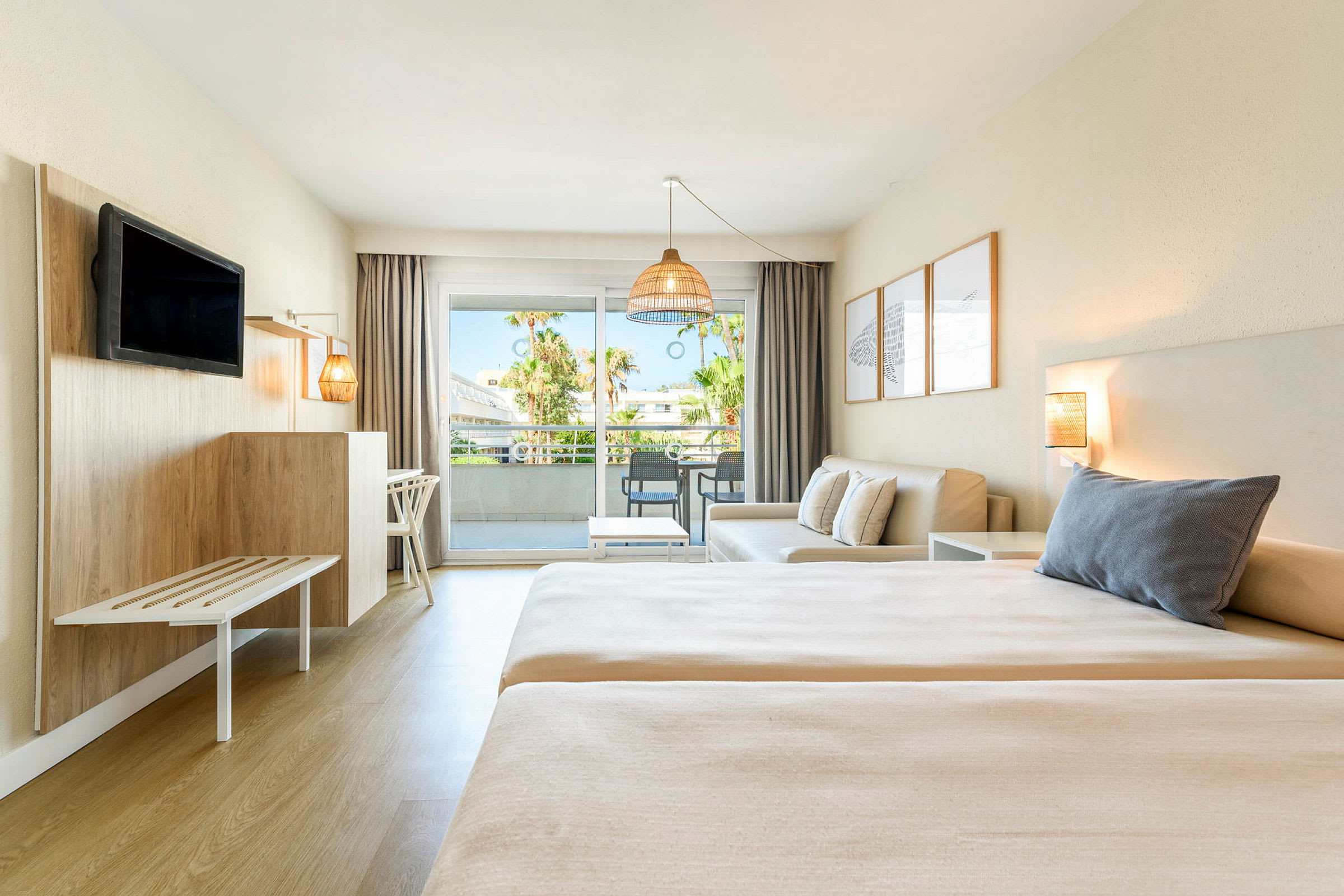 Ett hotellrum med två sängar, en sittgrupp och balkong med utsikt. (AI-genererad text)