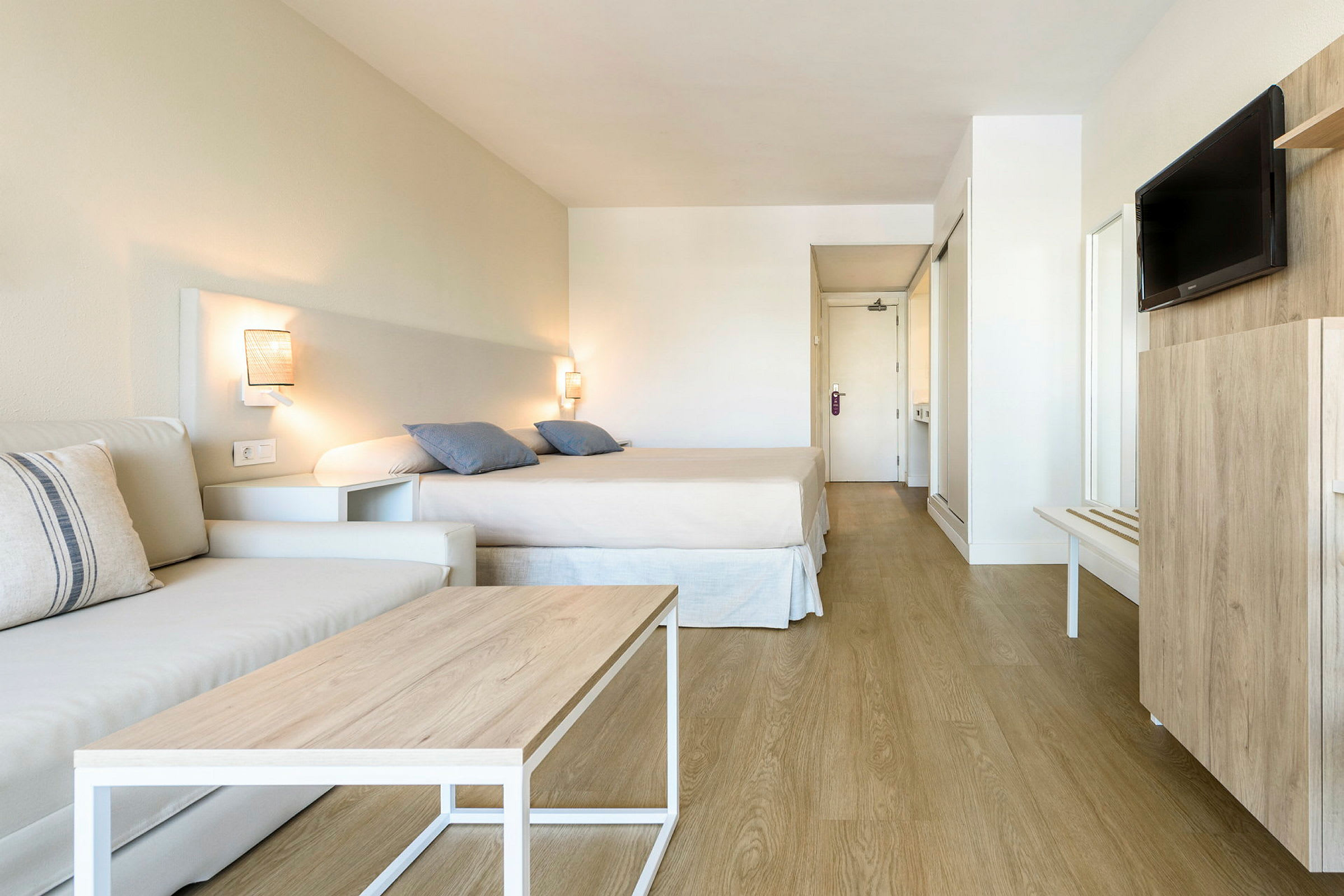 Ett hotellrum med säng, soffa och TV. (AI-genererad text)