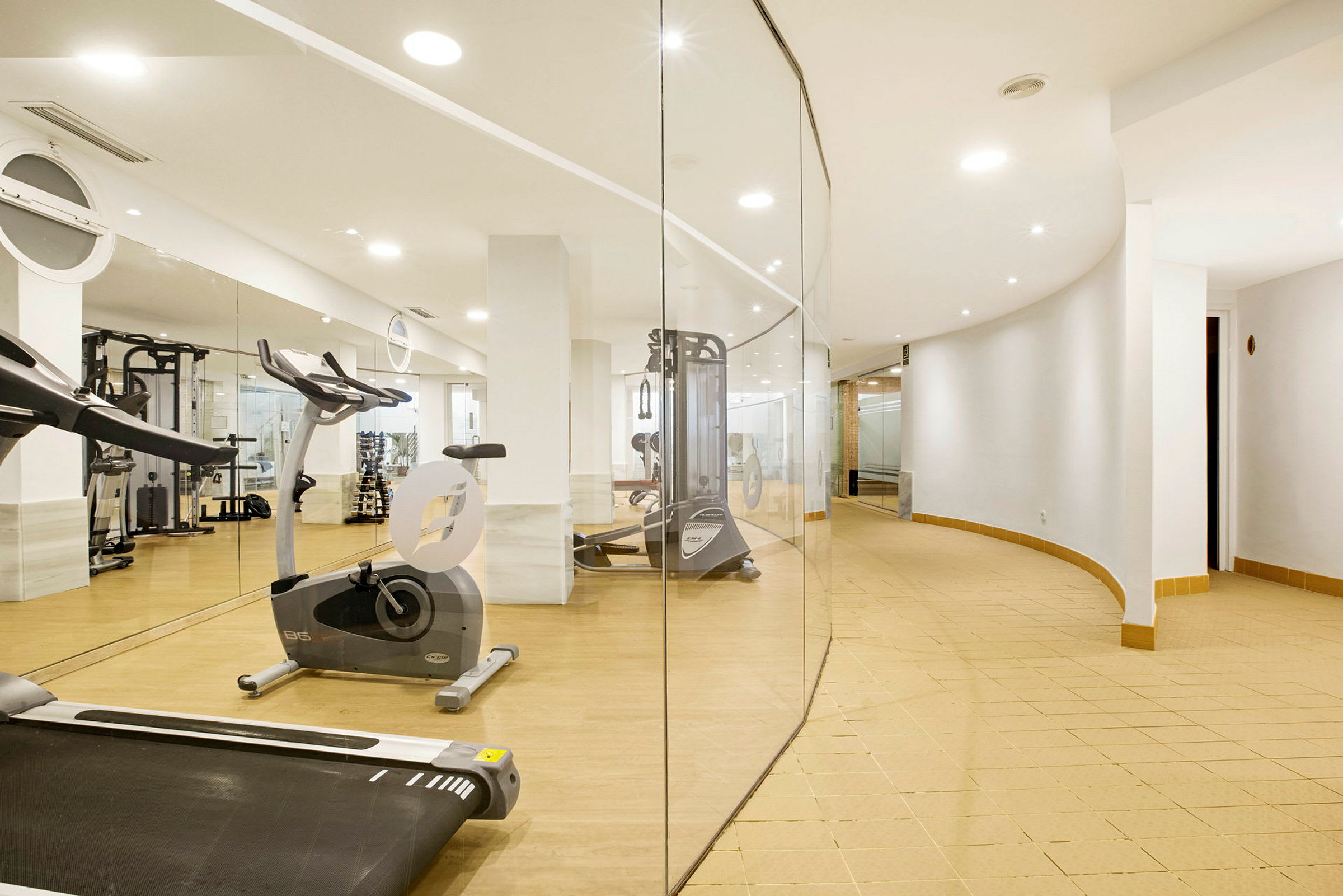 Ett gym med träningsutrustning och spegelväggar. (AI-genererad text)