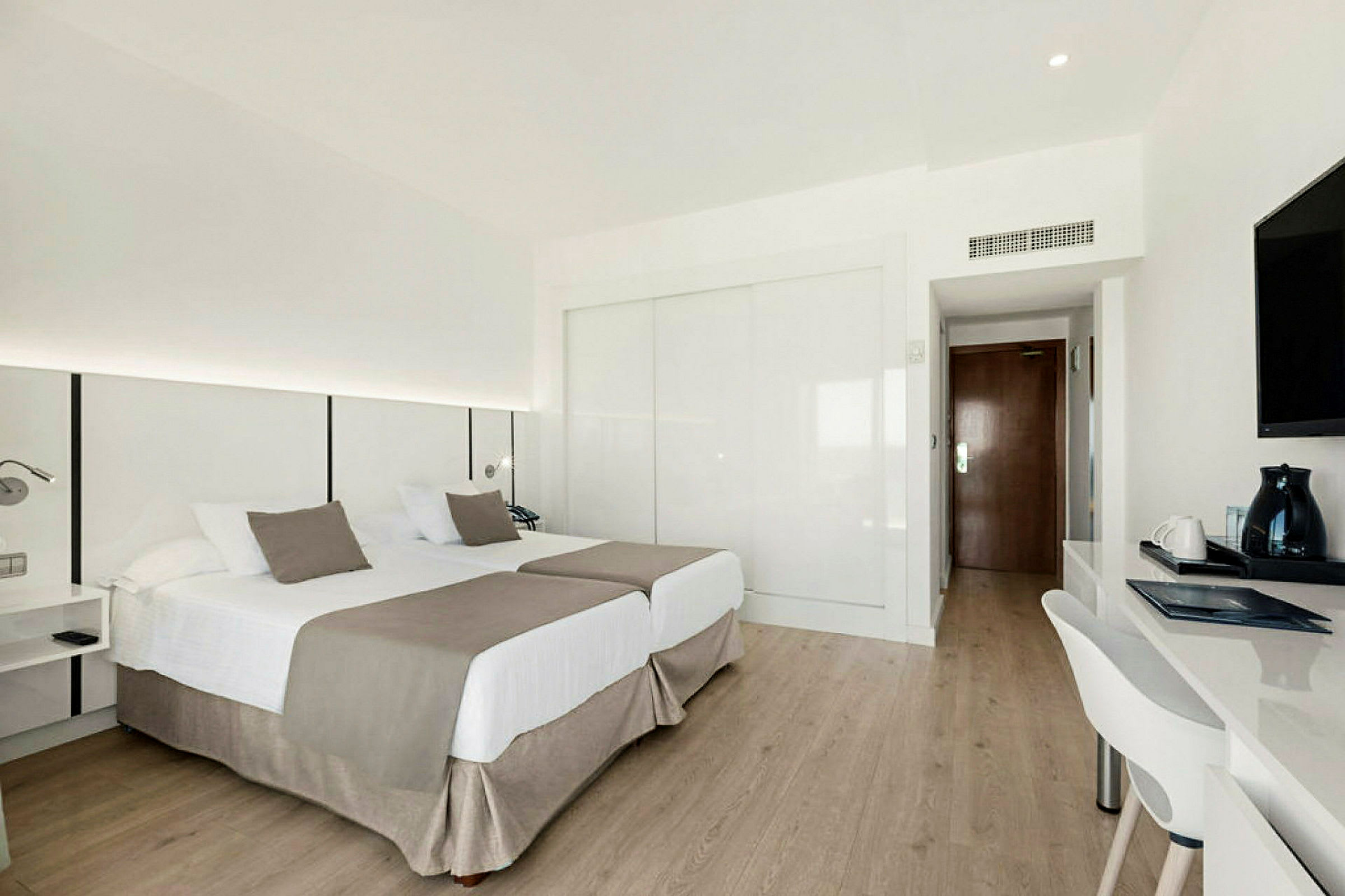 Ett hotellrum med två enkelsängar, skrivbord och TV. (AI-genererad text)