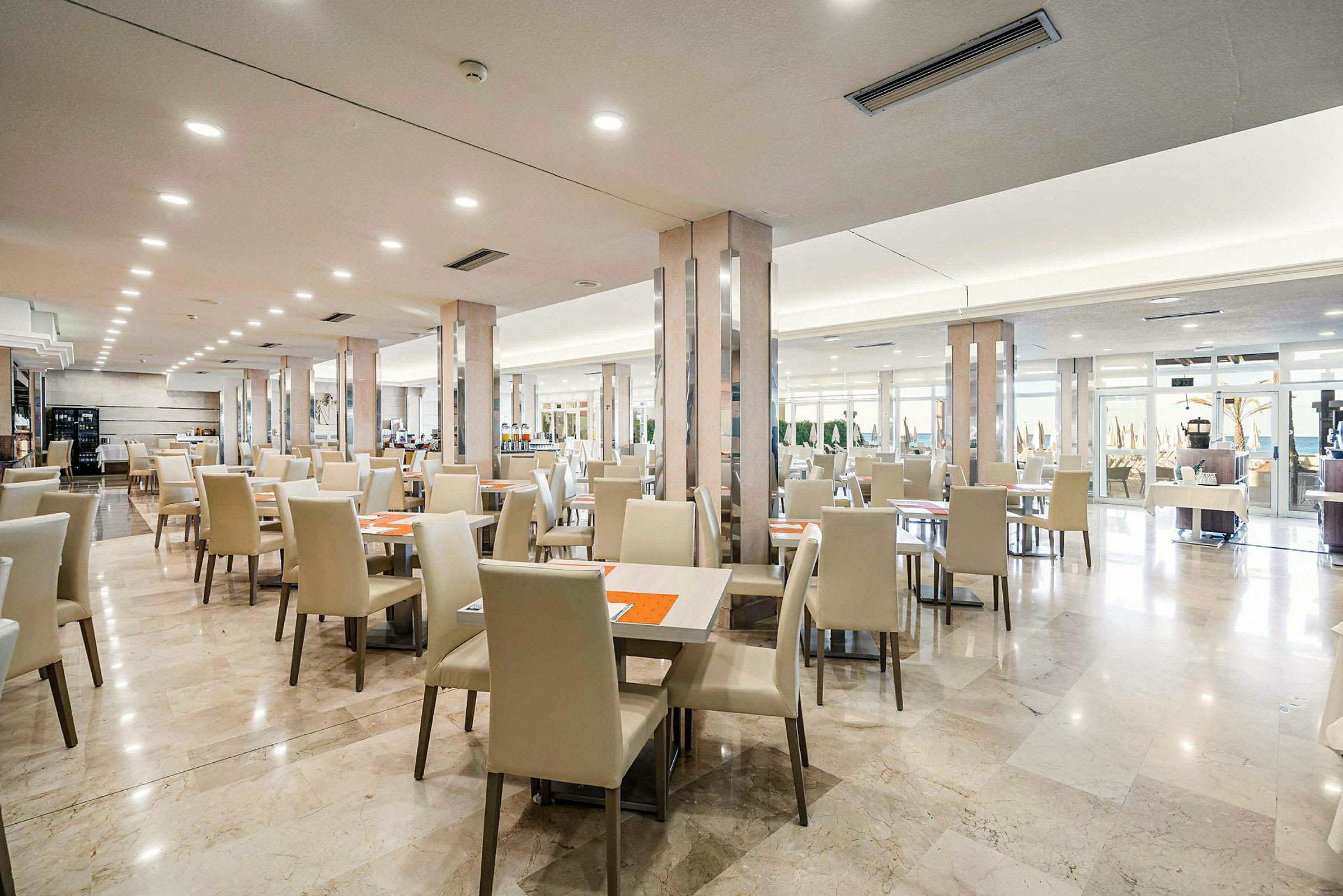 Bild av en rymlig restaurang med sittplatser och marmorgolv. (AI-genererad text)