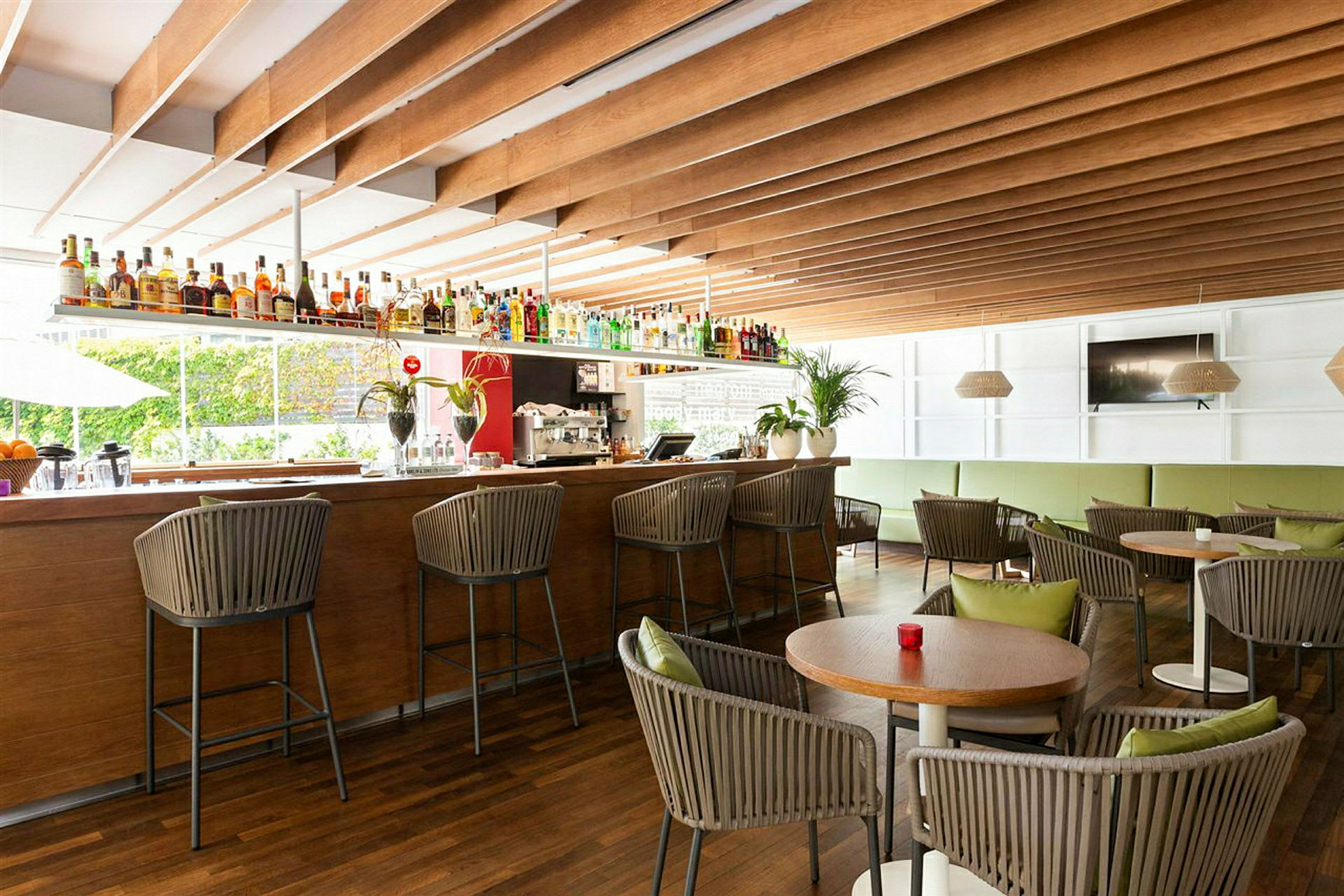 Restaurangbar med stolar och bord inredd i ljusa färger. (AI-genererad text)